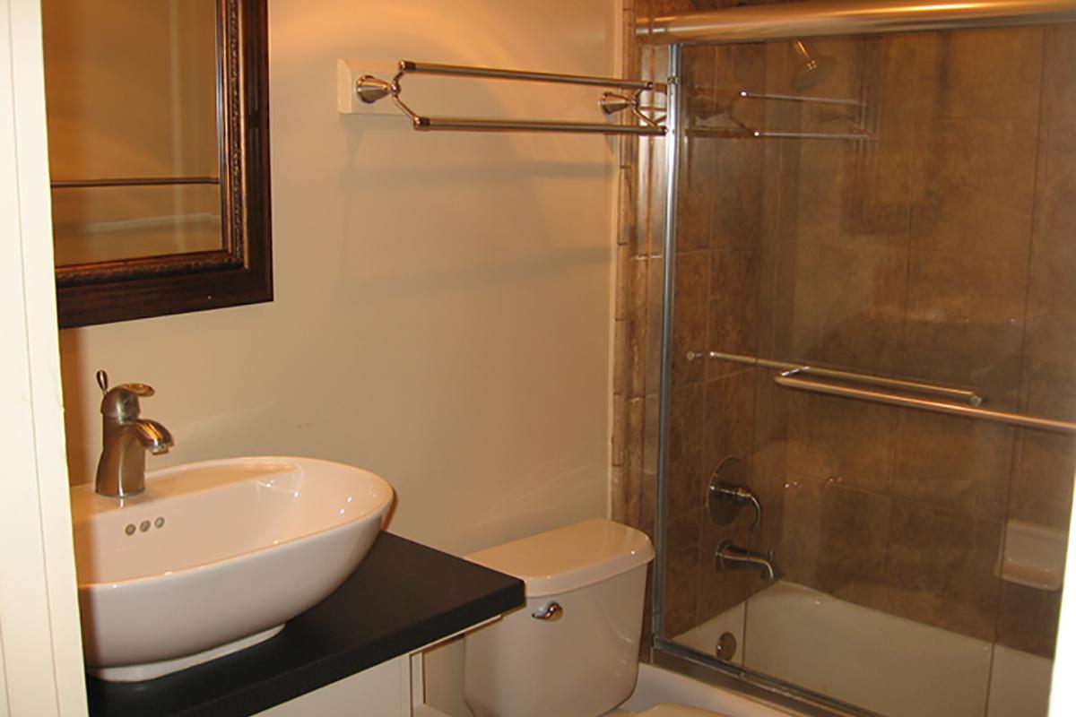 a white sink sitting next to a glass shower door