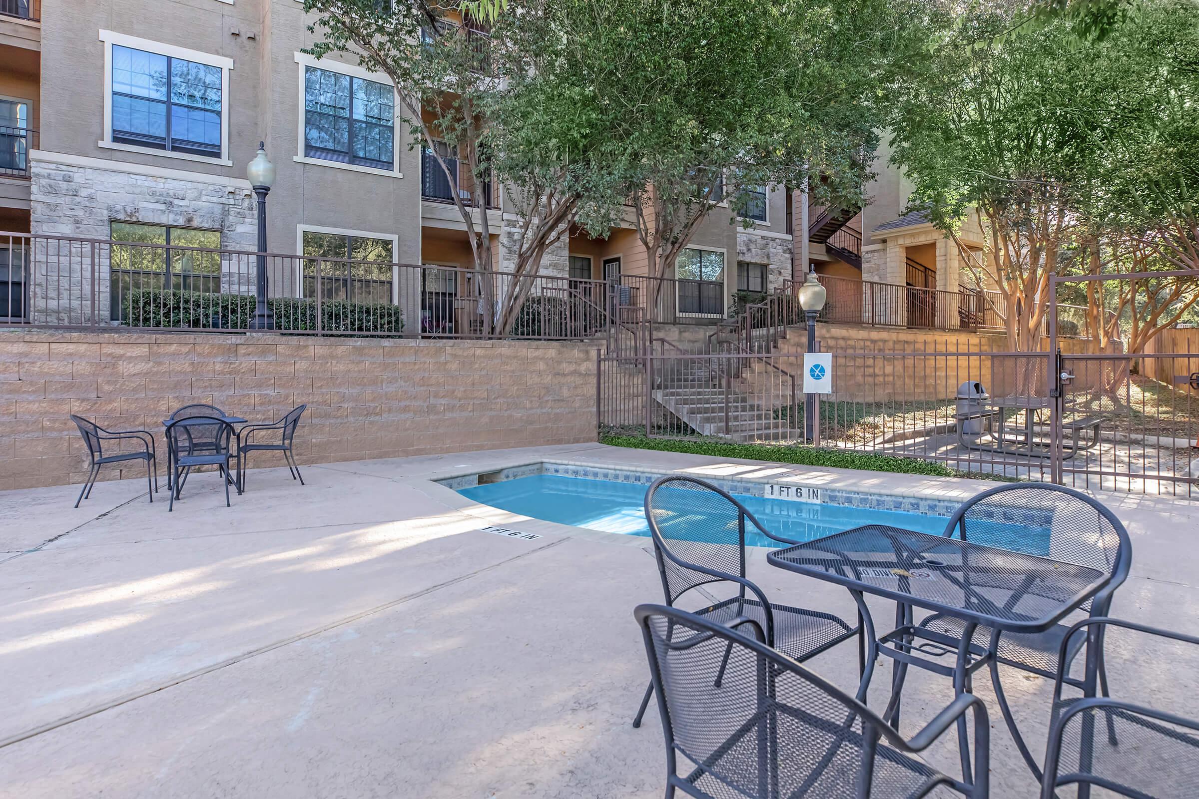 an empty park bench next to a pool