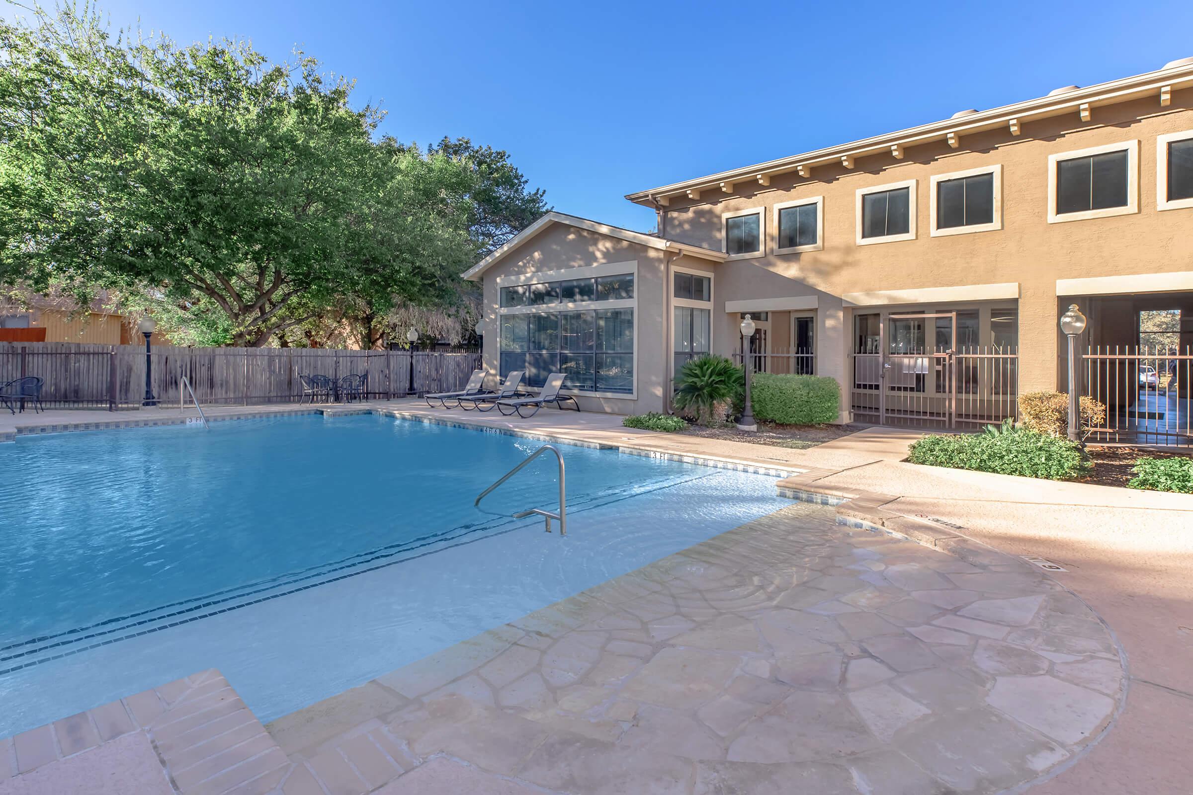 a large brick building with a pool in front of a house