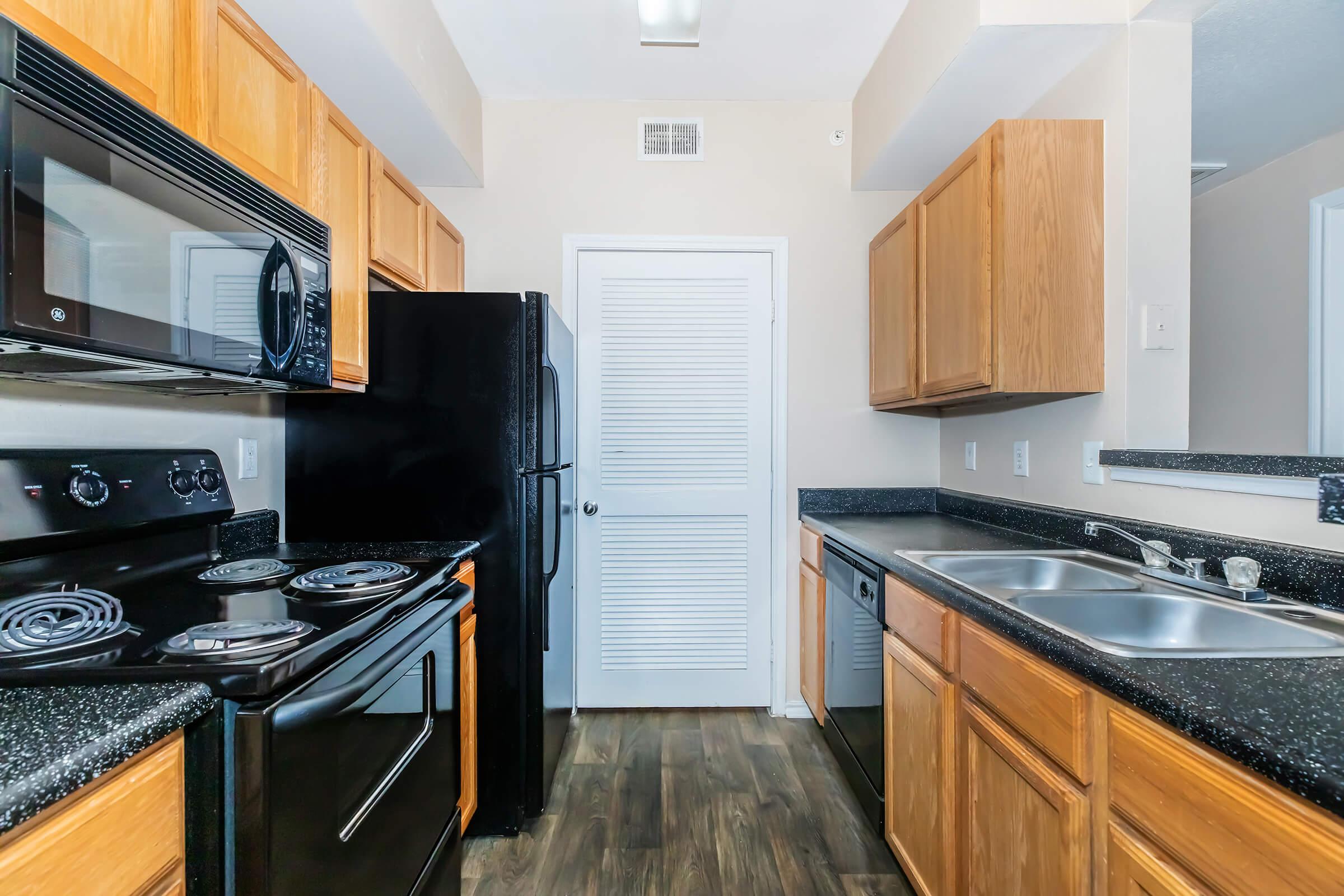 a modern kitchen with stainless steel appliances and wooden cabinets