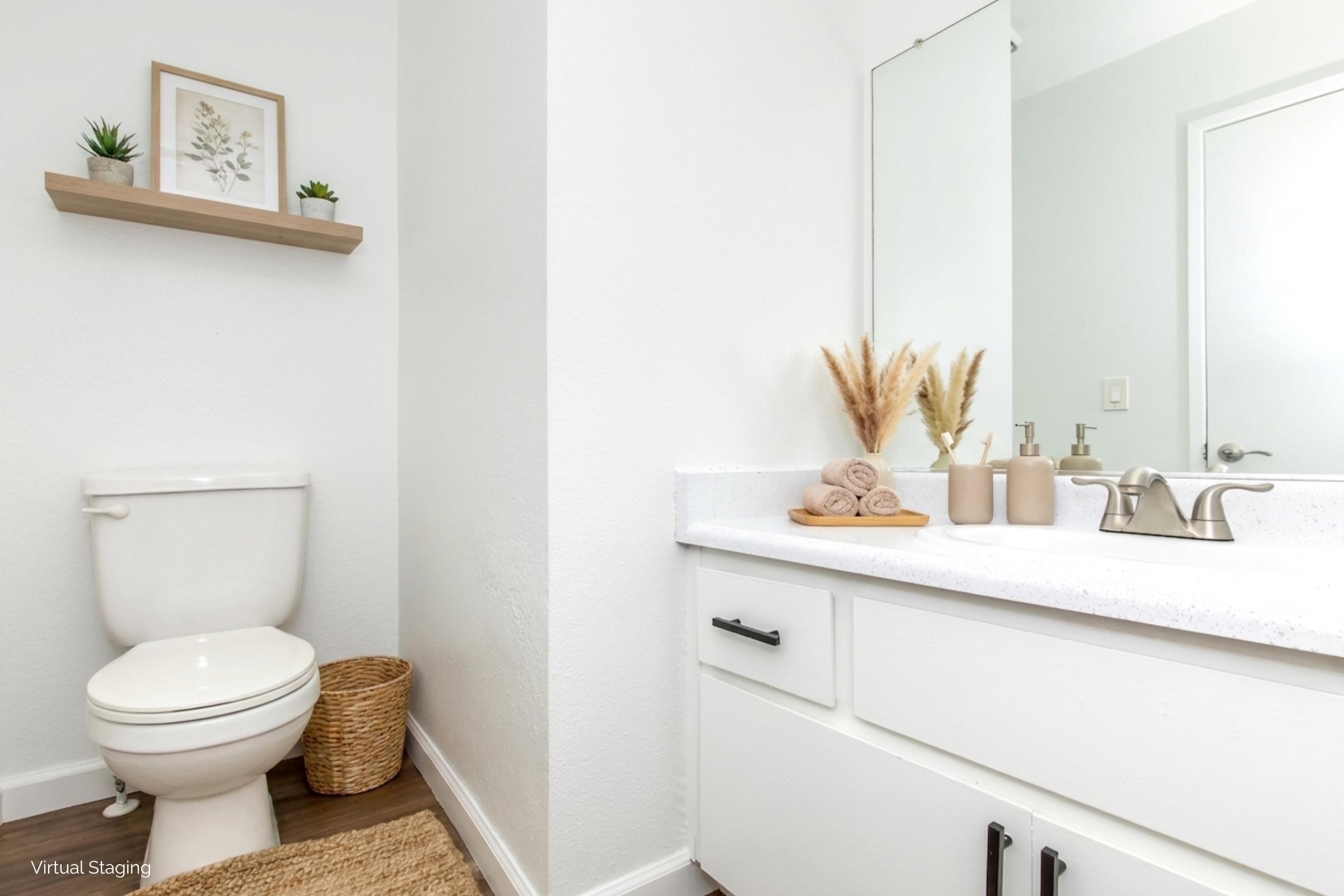 A clean, modern bathroom featuring a white toilet, a stylish vanity with a sink, and a large mirror. Decorative items include a shelf with potted plants and a woven basket. Neutral colors and natural accents create a calming atmosphere.