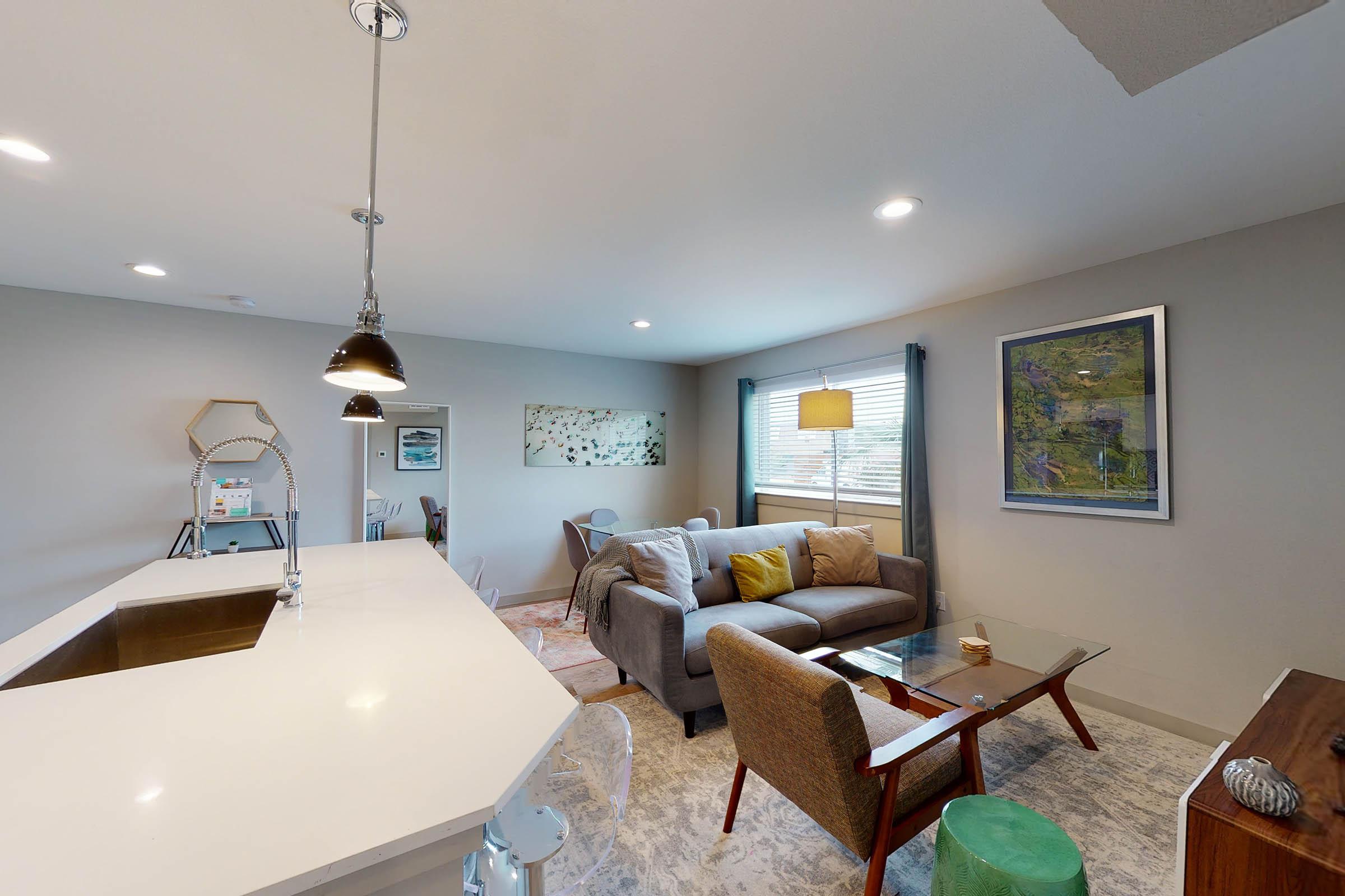 a furnished living room with a glass coffee table