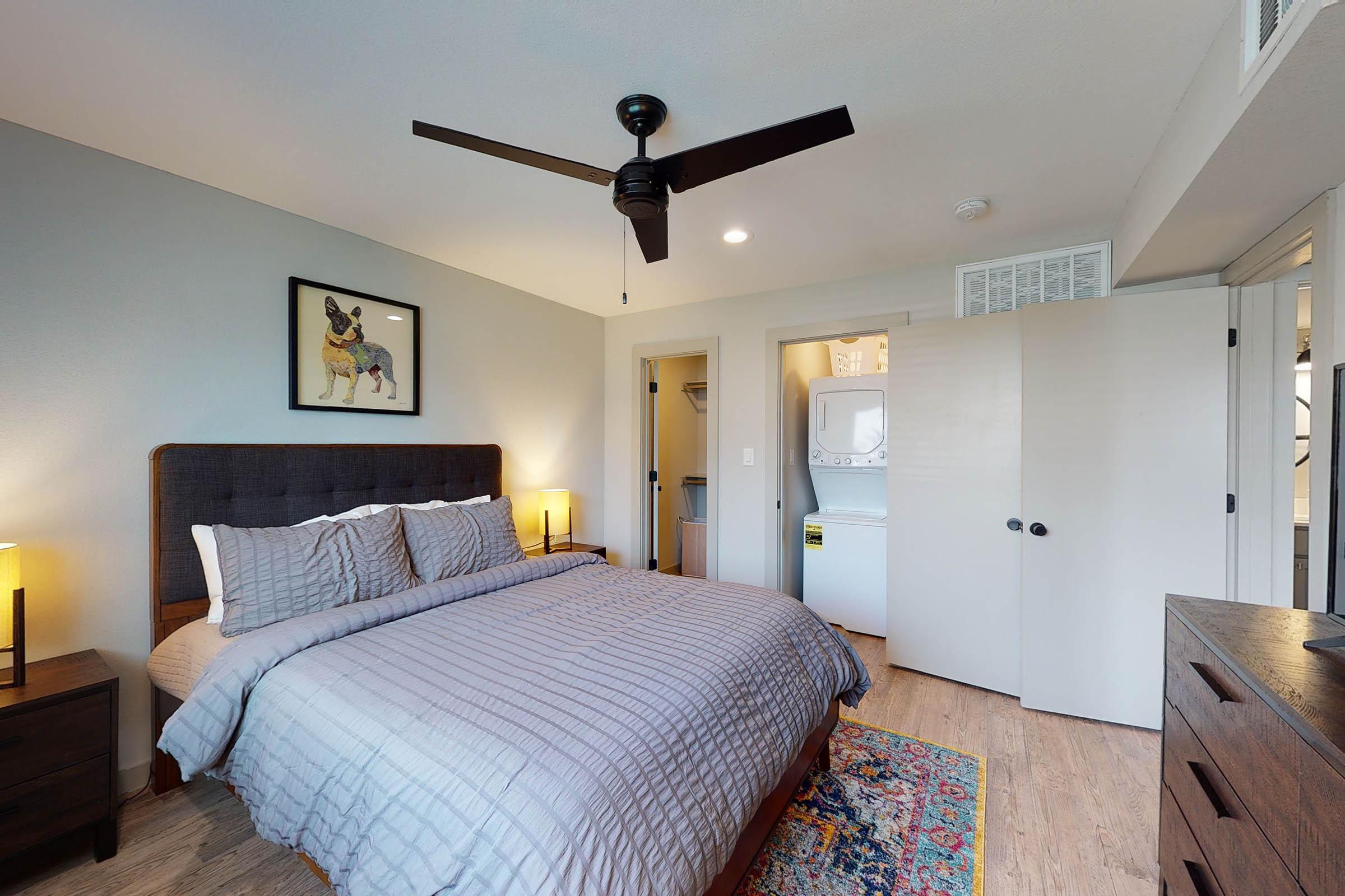 a furnished bedroom with a ceiling fan