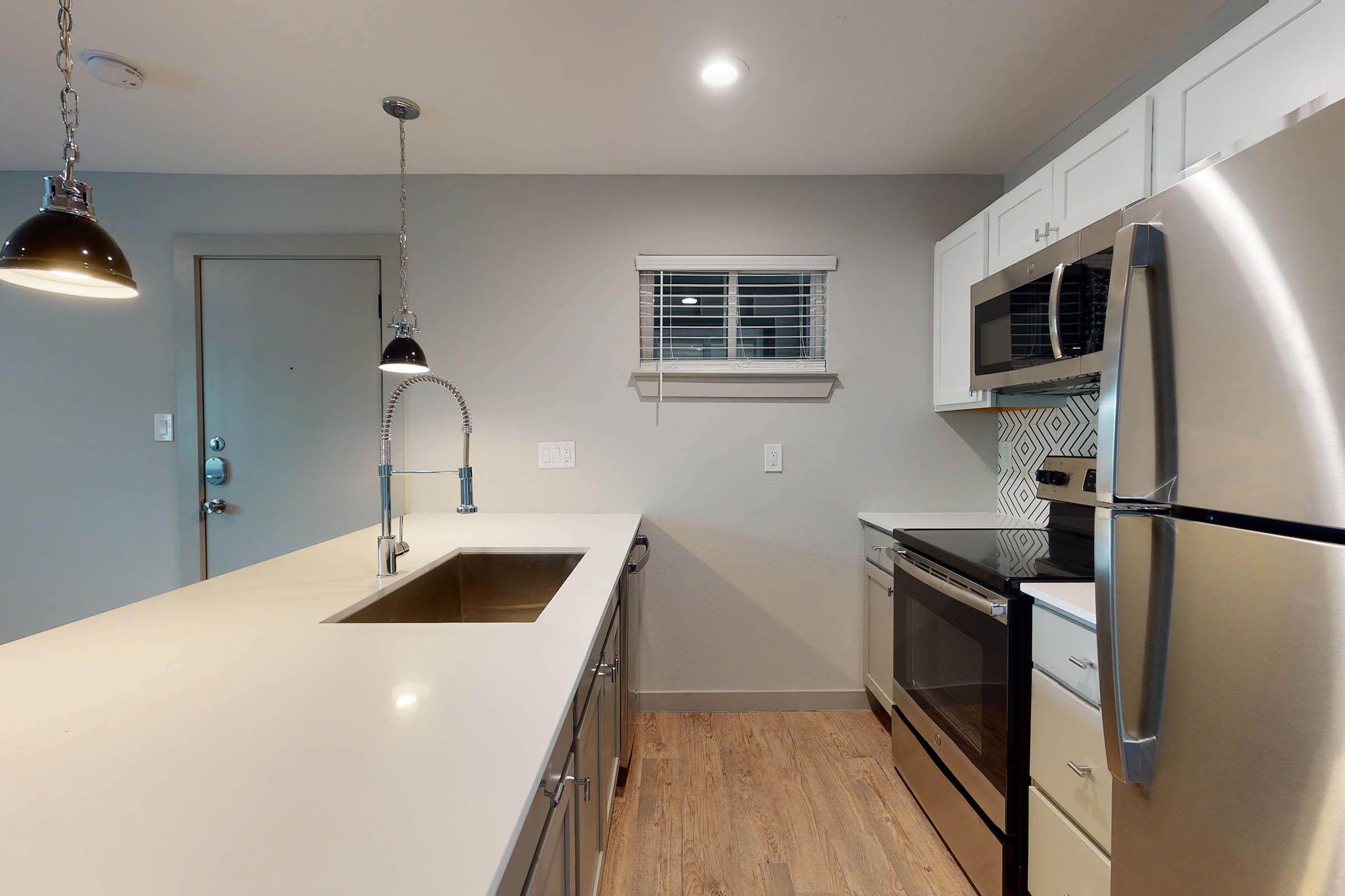 a kitchen with wooden floors and cabinets