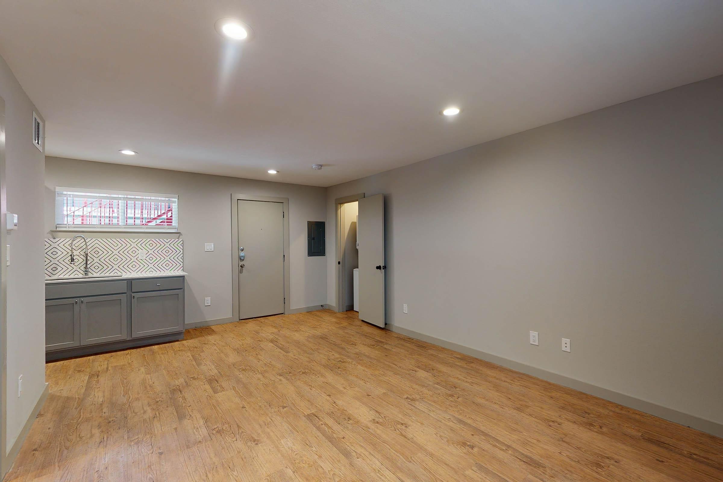 an unfurnished living room with wooden floors