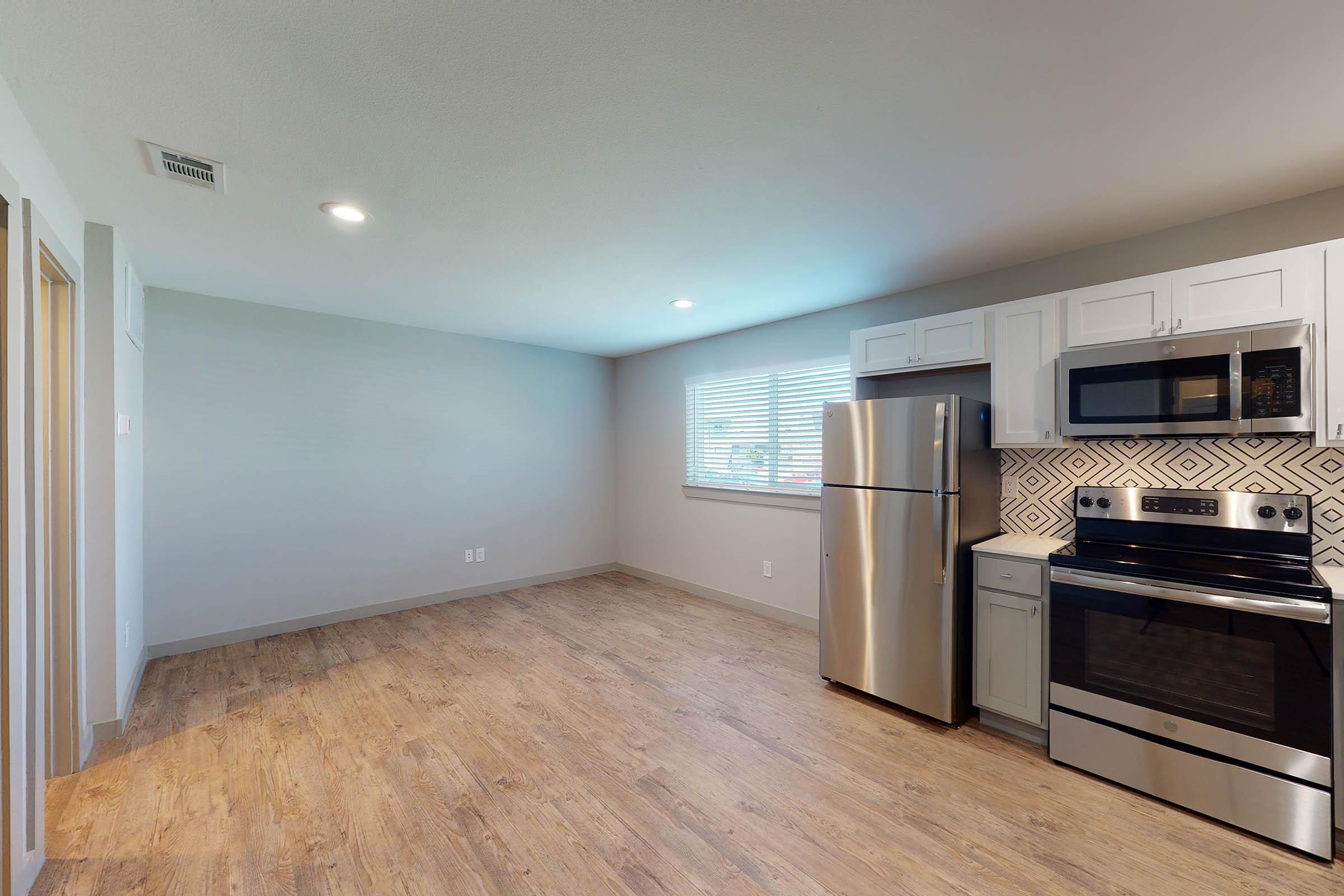 vacant kitchen and dining room with wooden floors