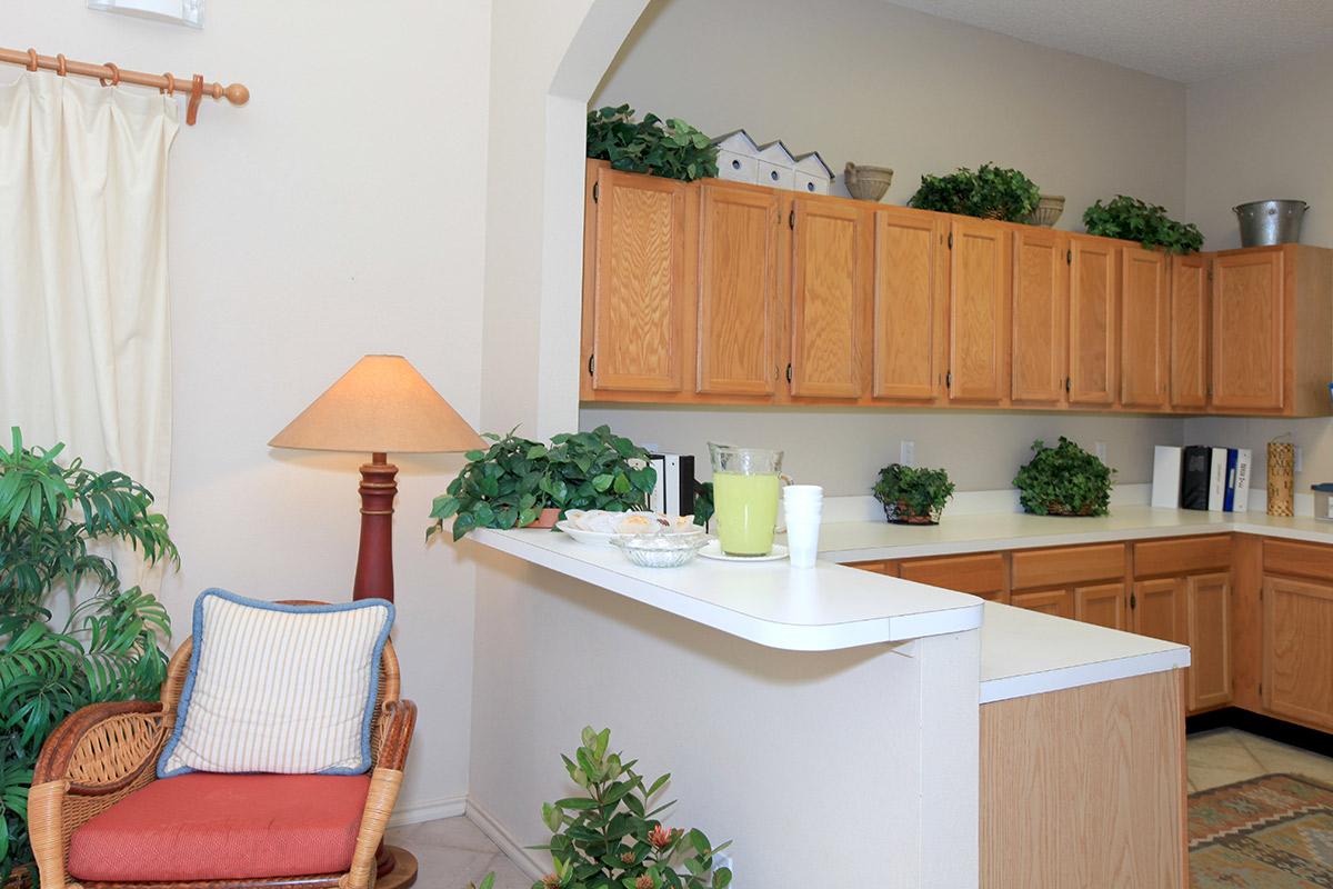 a living room filled with furniture and a table in a kitchen