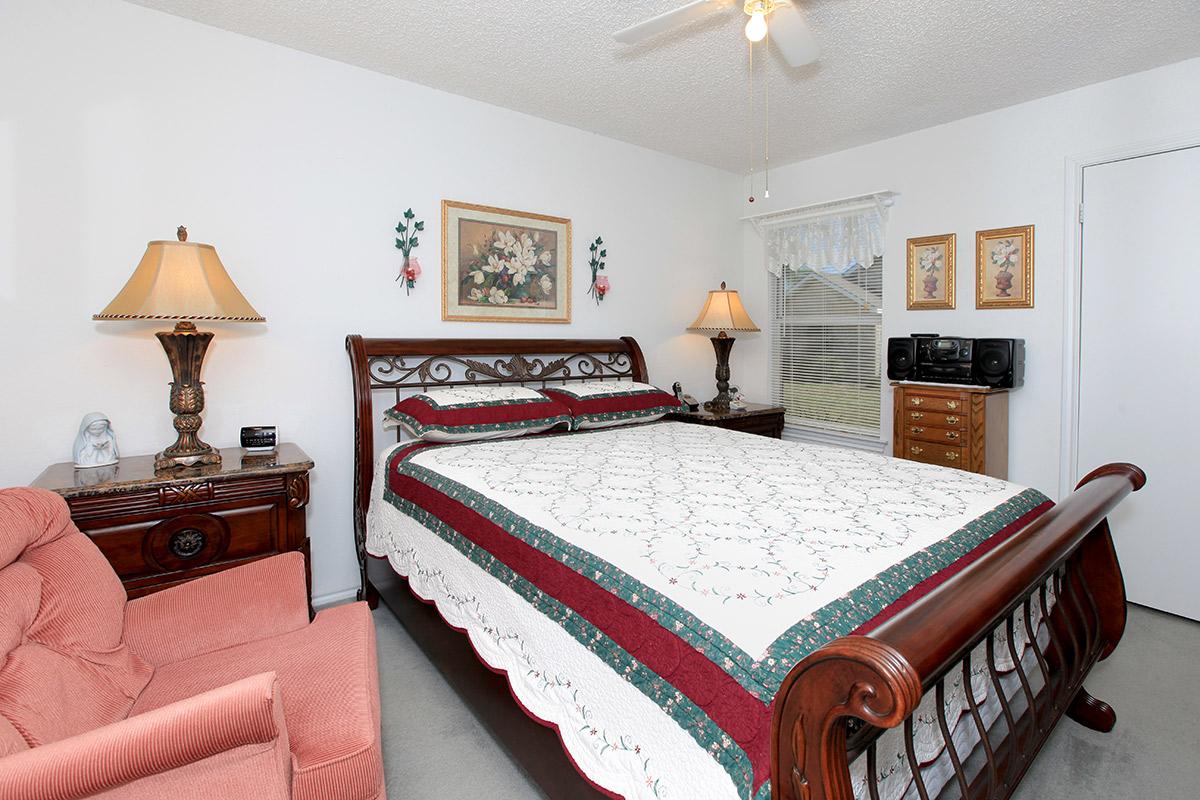 a bedroom with a bed and desk in a room