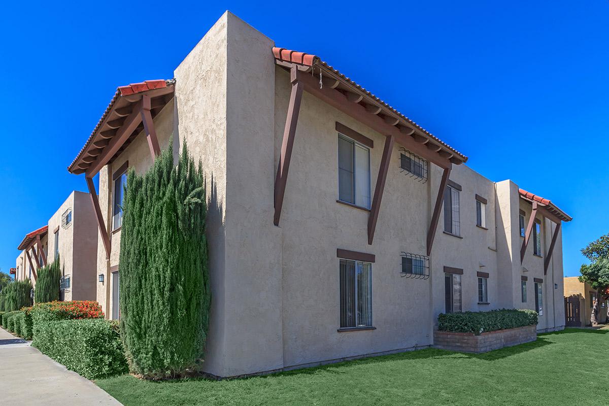 a large brick building with grass in front of a house