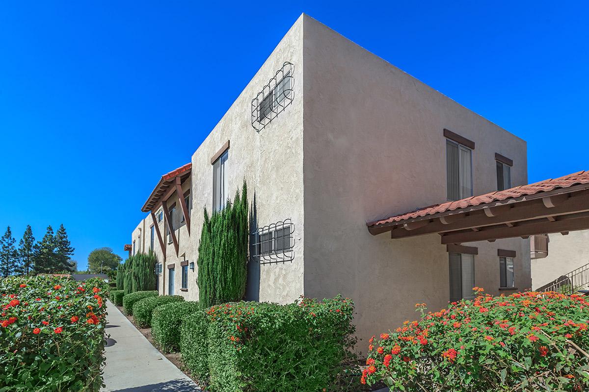 a house with bushes in front of a brick building