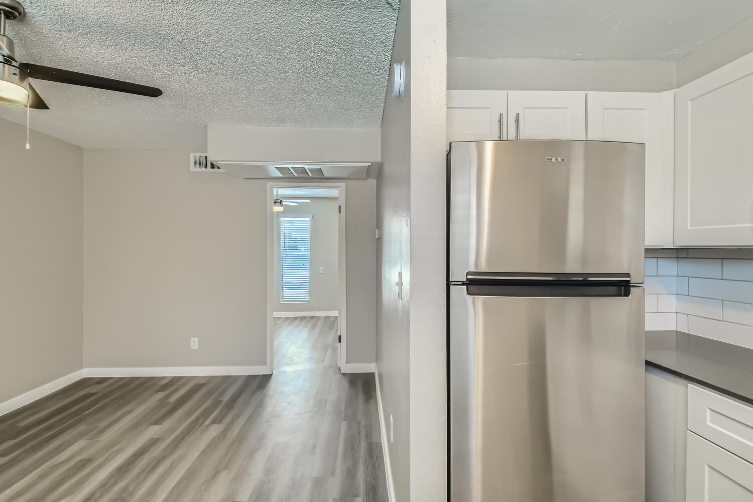A stainless steel fridge in the kitchen and living area at Rise at the Palms.