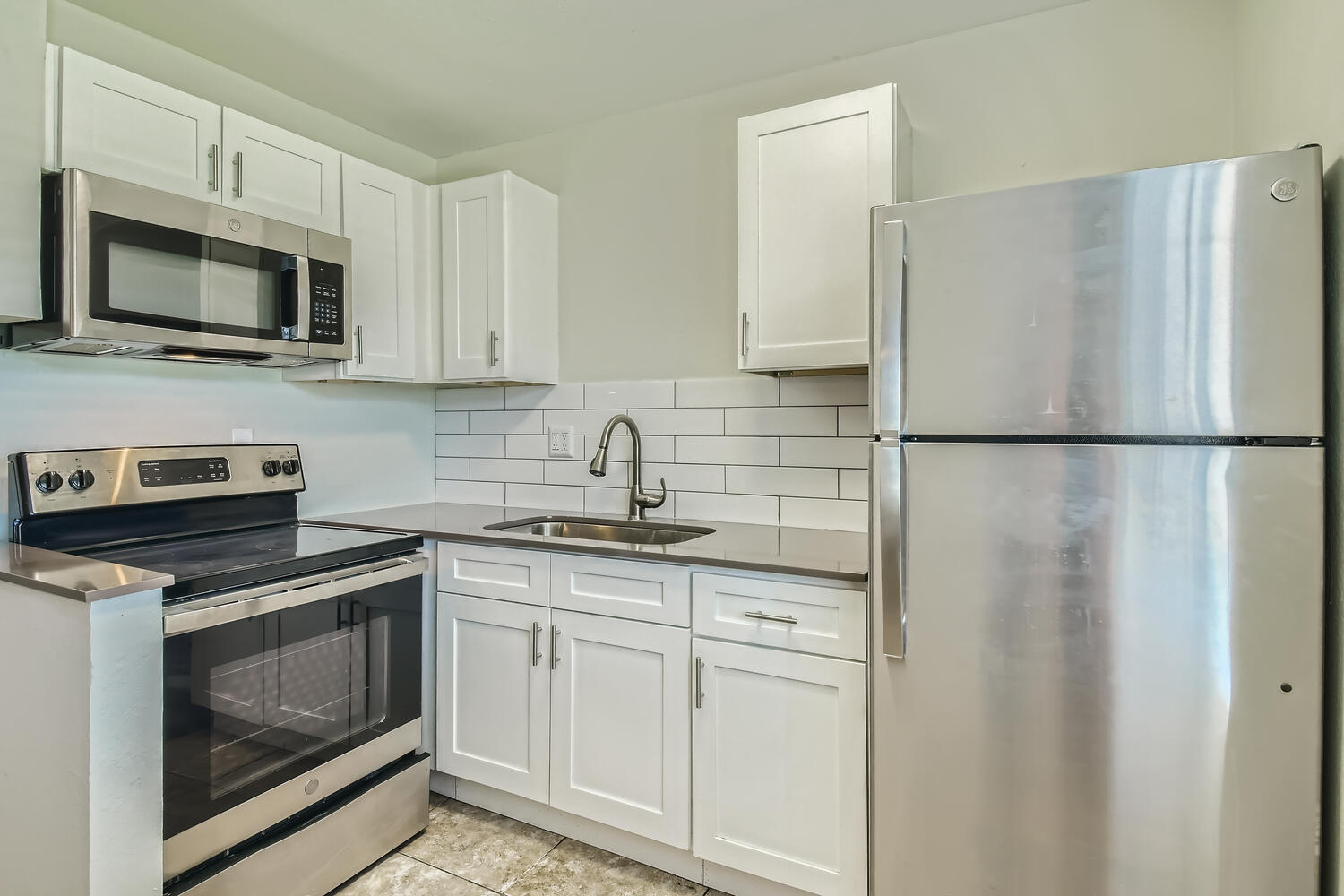 The kitchen with stainless steel appliances and white shaker cabinets at Rise at the Palms.