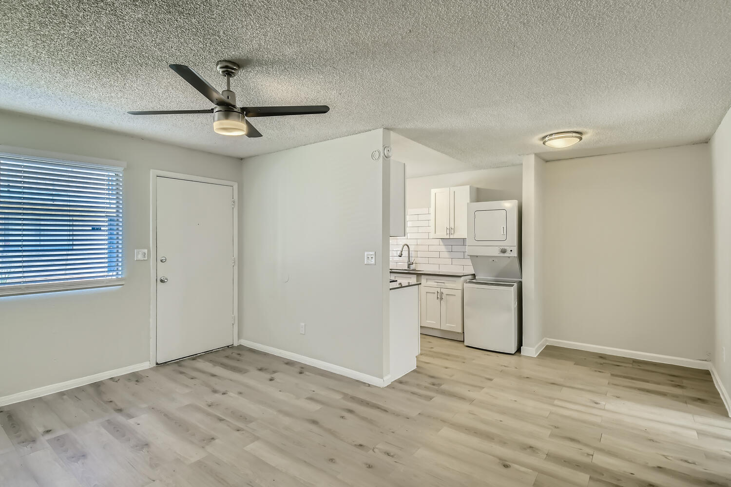 A remodeled apartment living room and kitchen with wood-style flooring at Rise at the Palms.