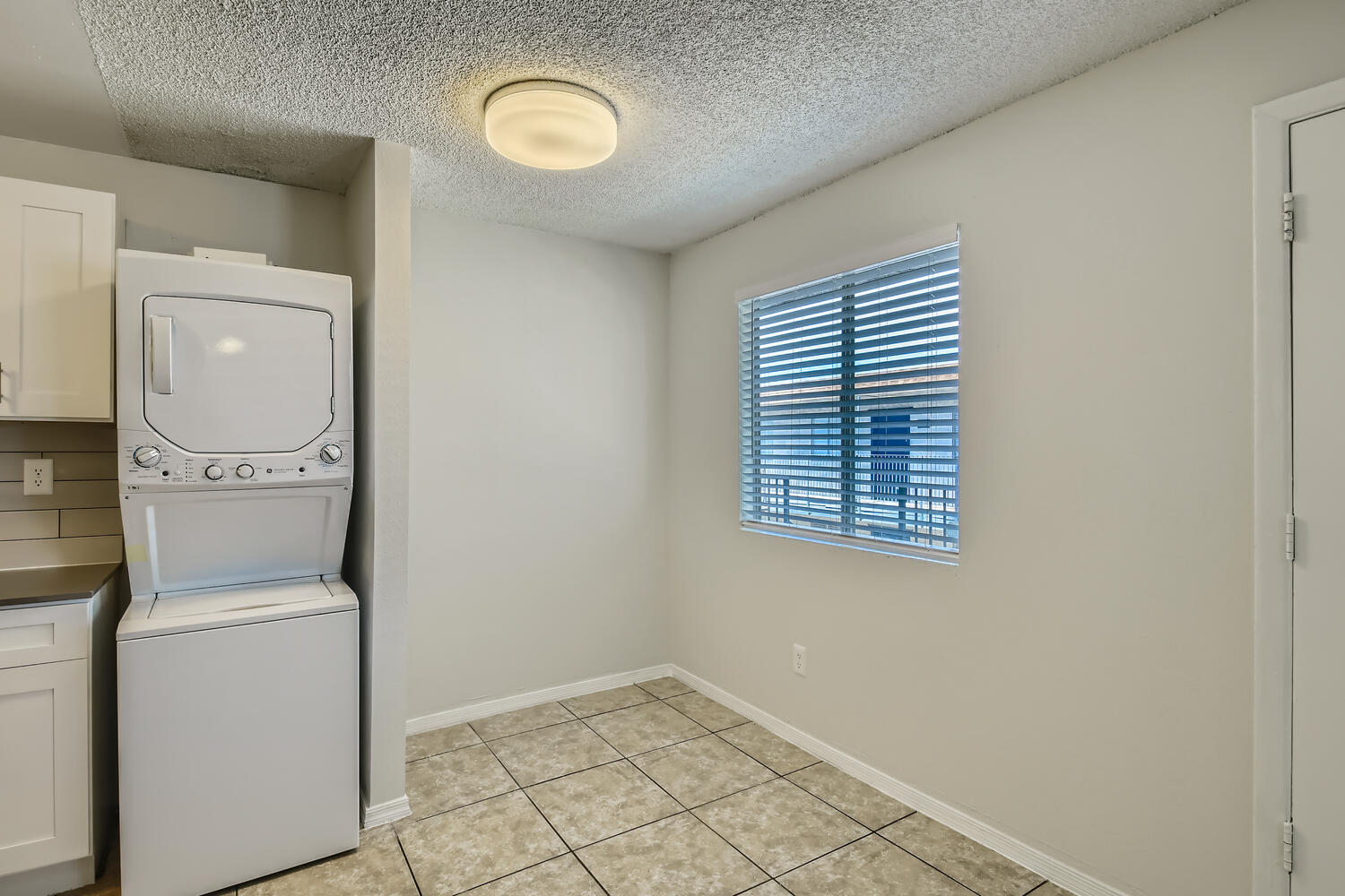 A room near the kitchen with a washer and dryer at Rise at the Palms.