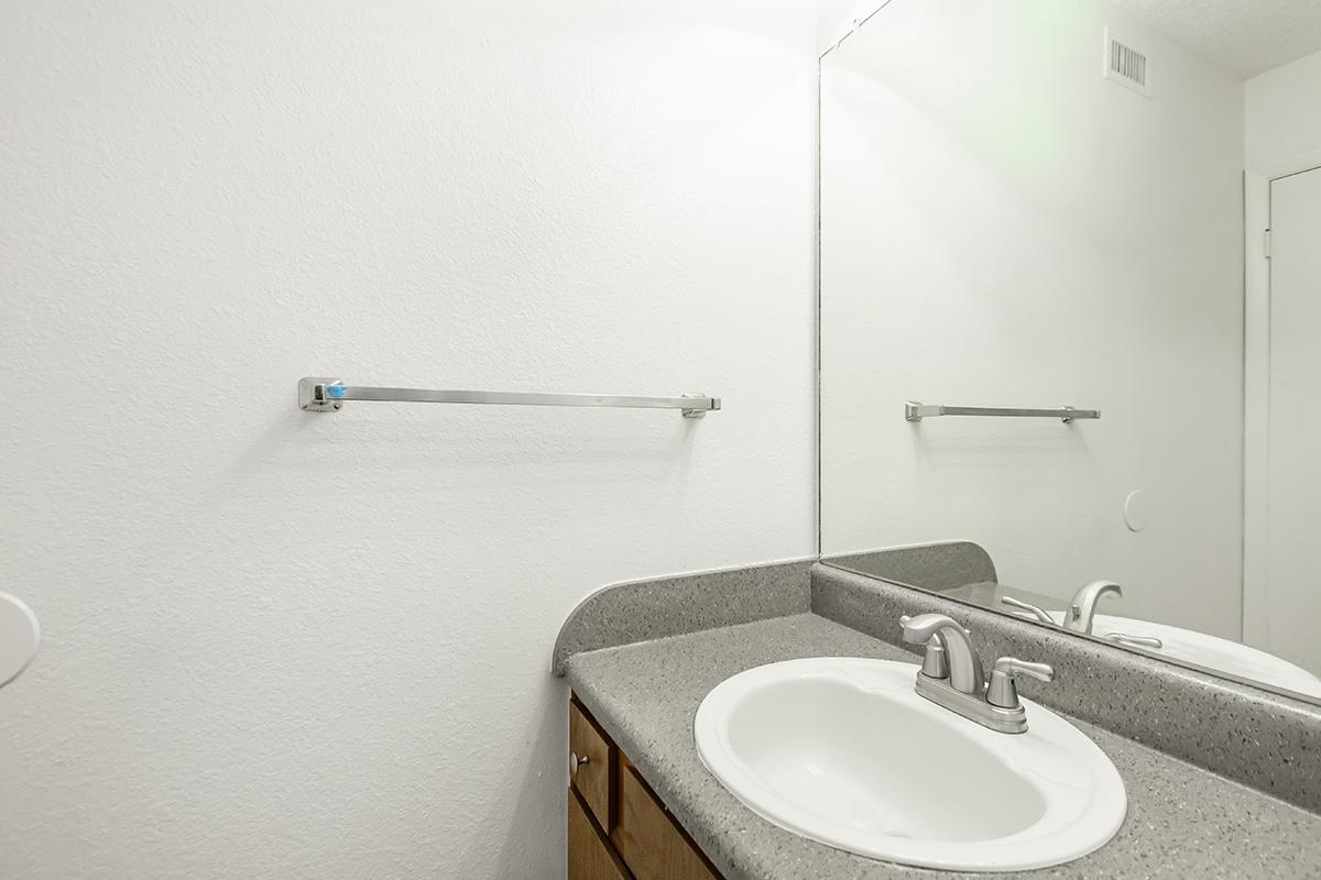 a white sink sitting under a mirror
