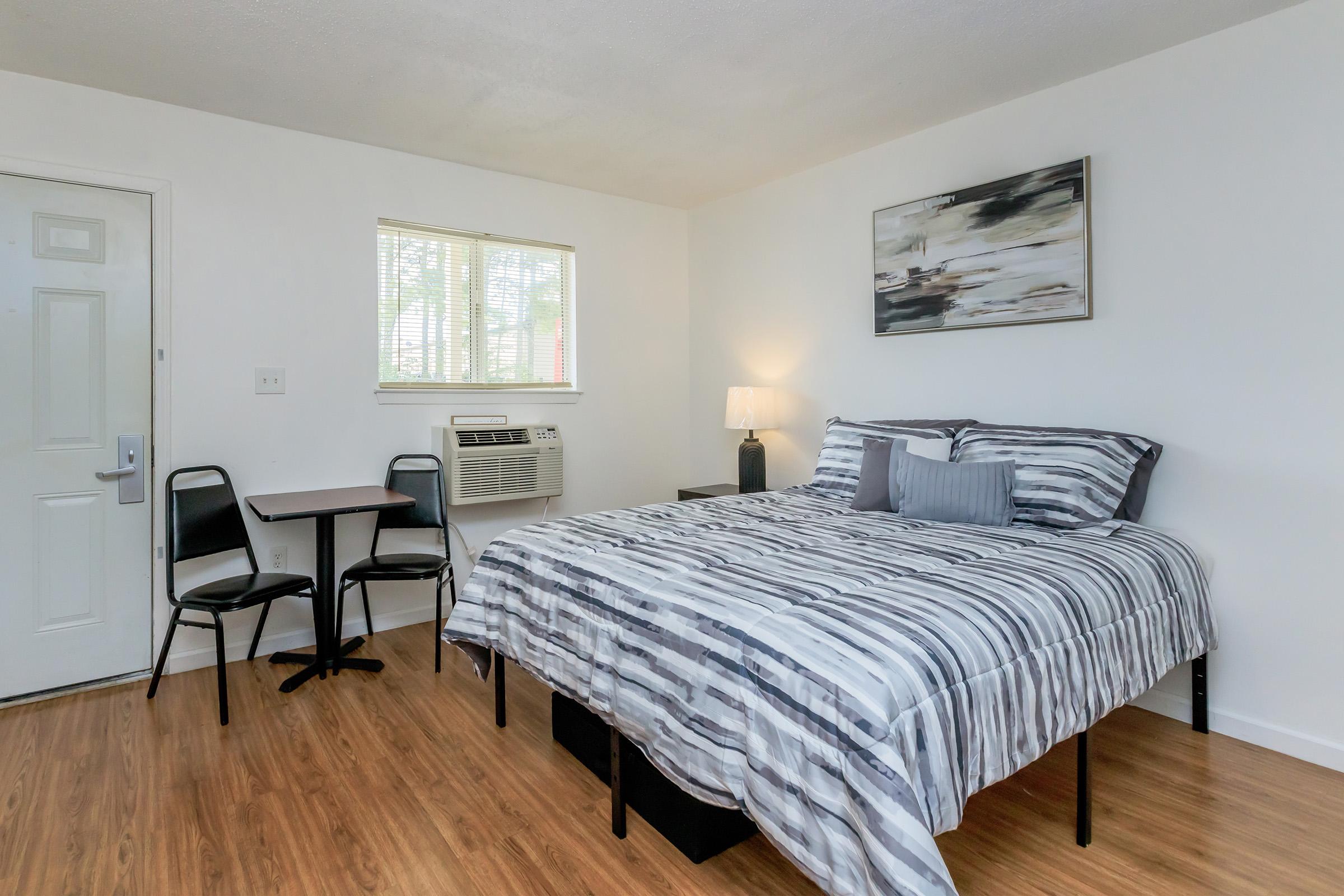 a bedroom with a bed and desk in a room