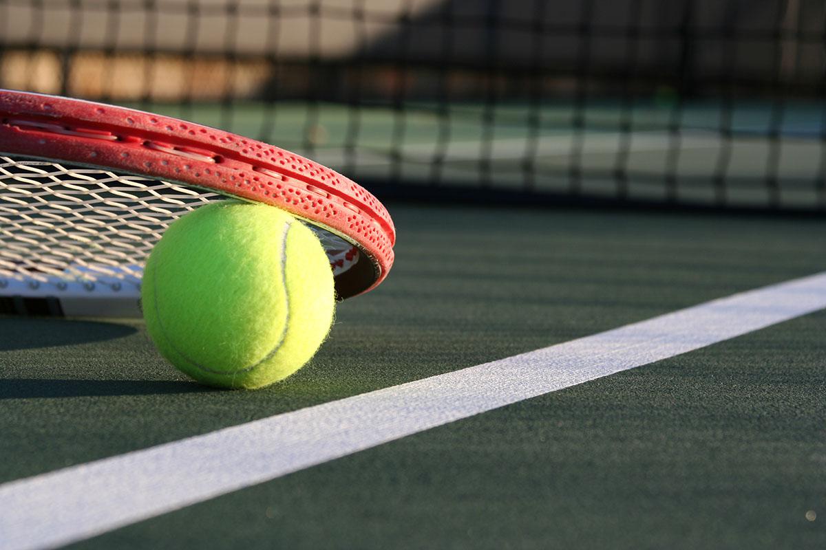 a green ball on a court with a racket