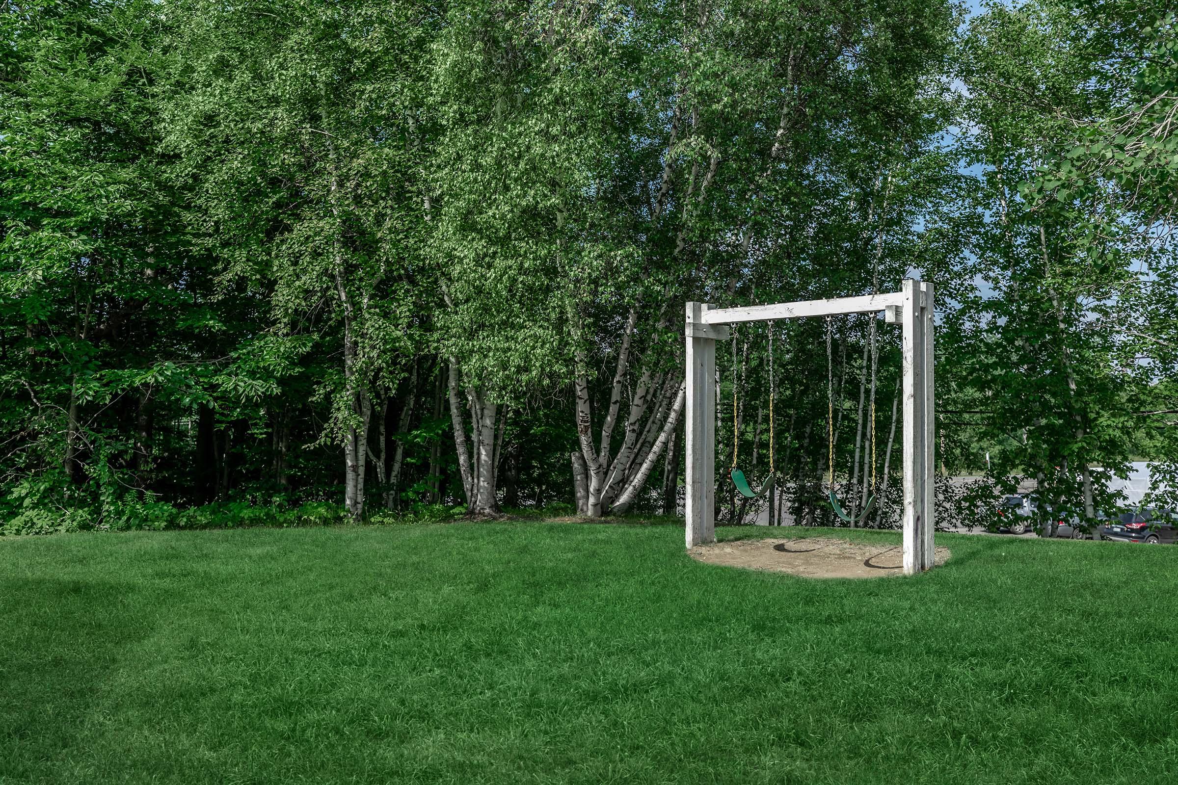 a green field with trees in the background