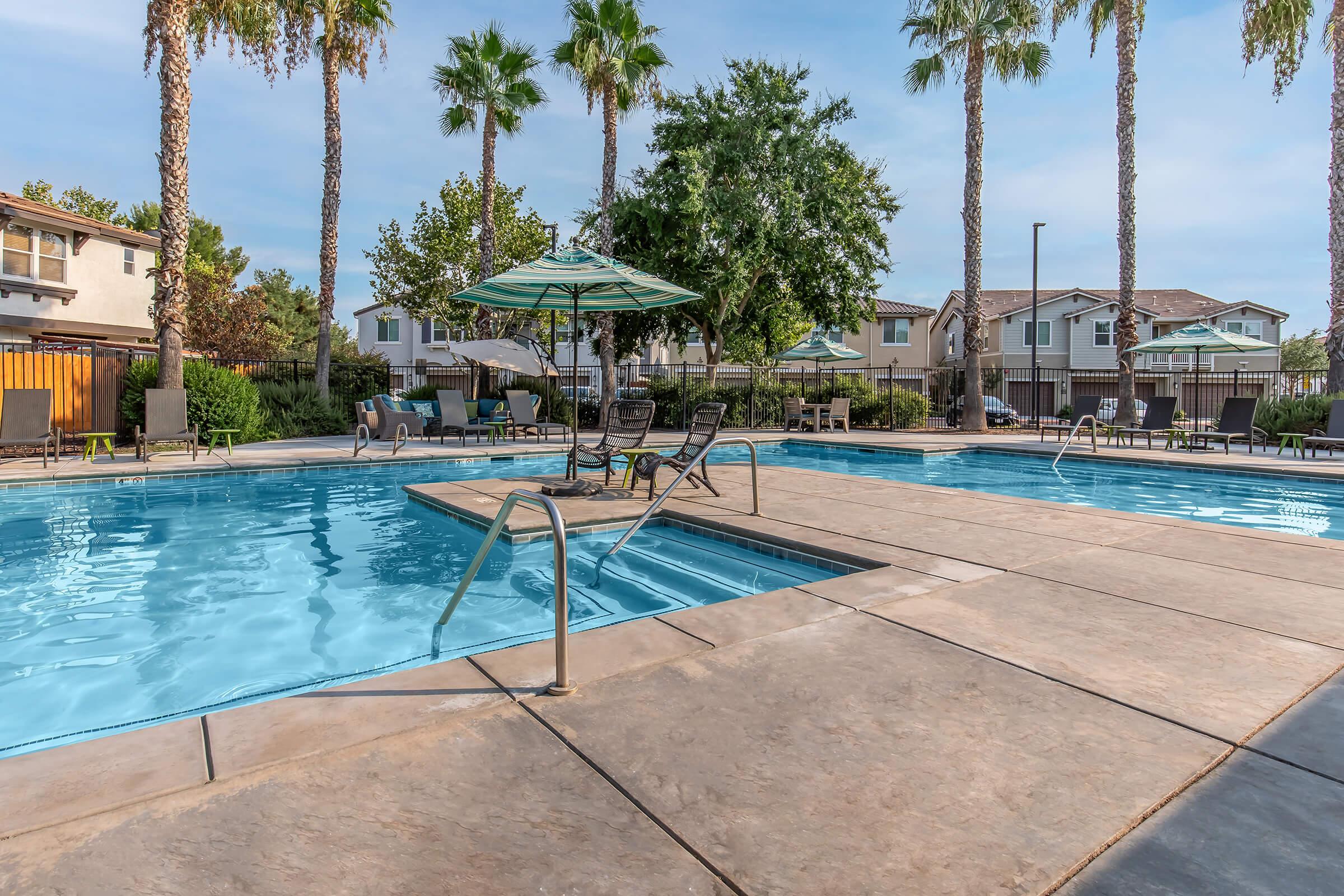 a row of palm trees next to a pool of water