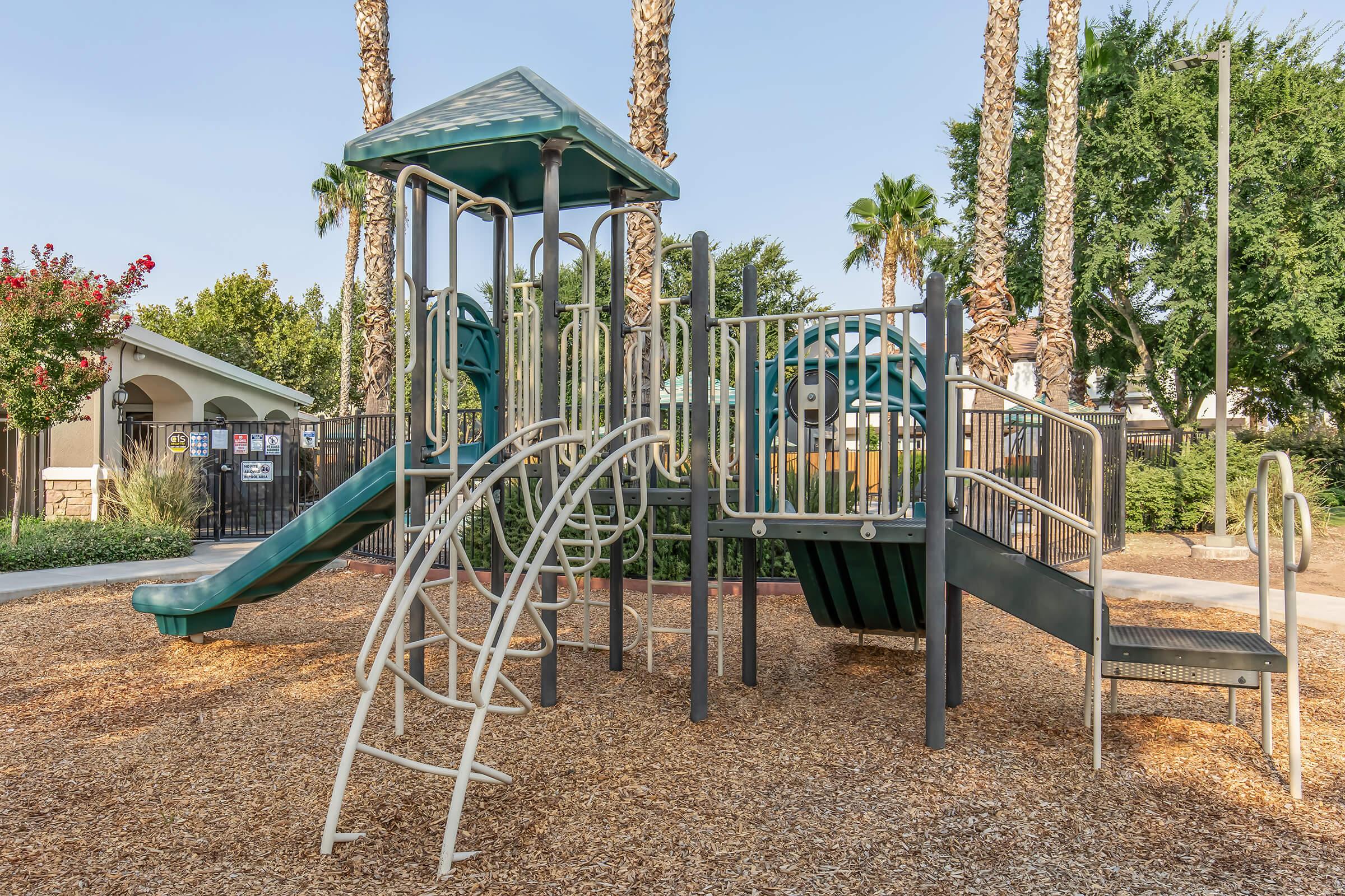 2 Bedroom Apartments In Fresno County CA - Parador Townhomes - Playground Structure On Wood-Chips Featuring Slide