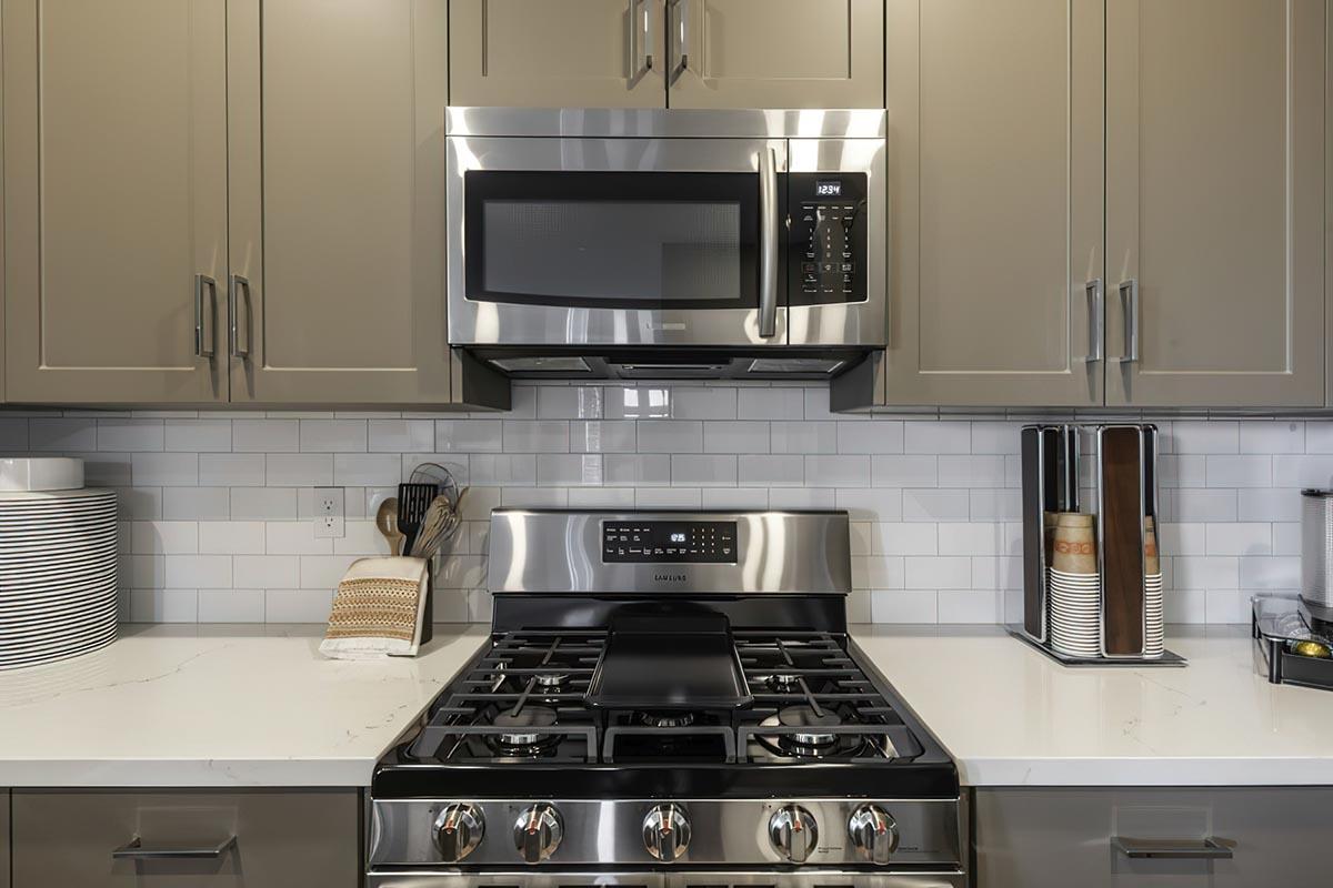 Two Bedroom Apartments In East Fresno CA - Parador Townhomes - Modern Kitchen Featuring Stainless Steel Appliances, Light Gray Cabinetry, And Subway Tile Backsplash