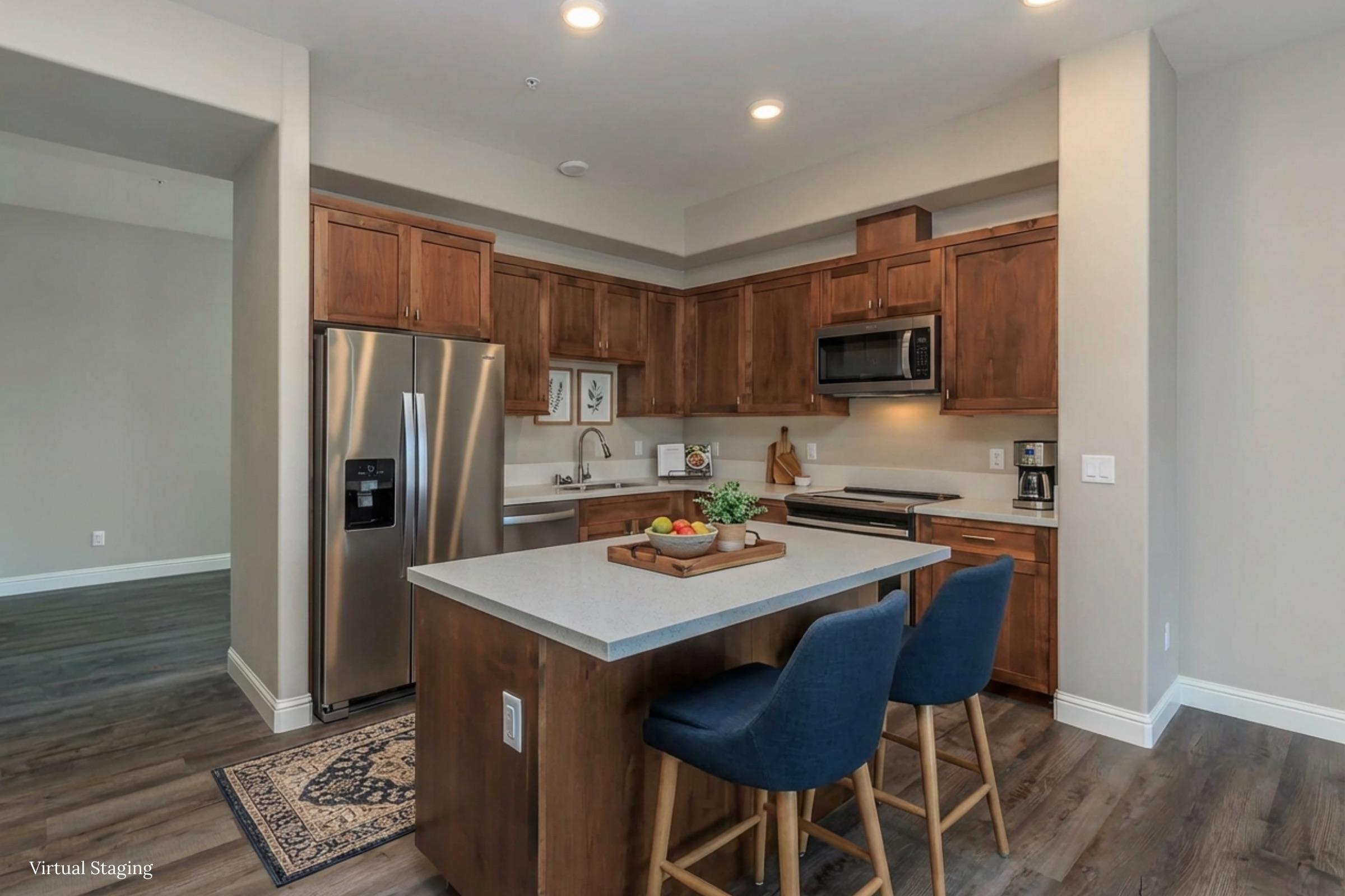 Modern kitchen featuring wood cabinetry, stainless steel appliances, and a spacious island with bar stools. The countertop is adorned with a fruit basket, and the flooring is a blend of light and dark tones, contributing to an inviting atmosphere. Natural light brightens the area, highlighting the contemporary design.