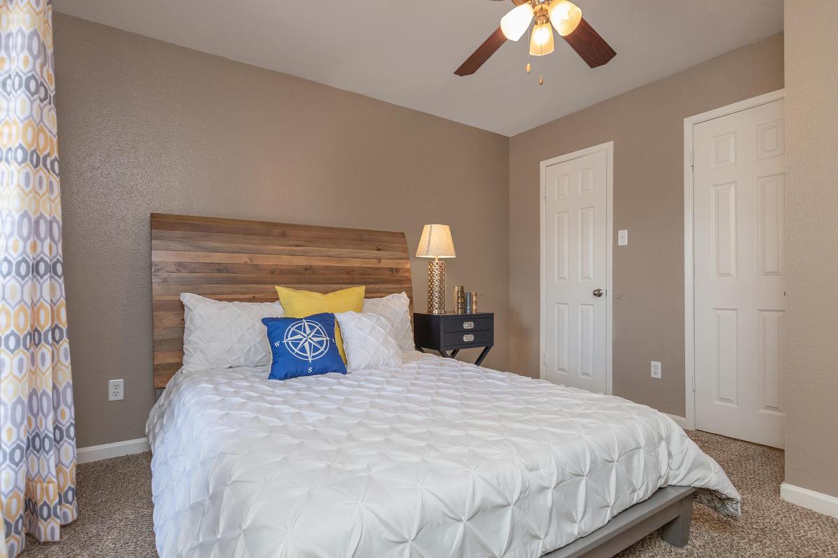 a bedroom with a bed and desk in a room