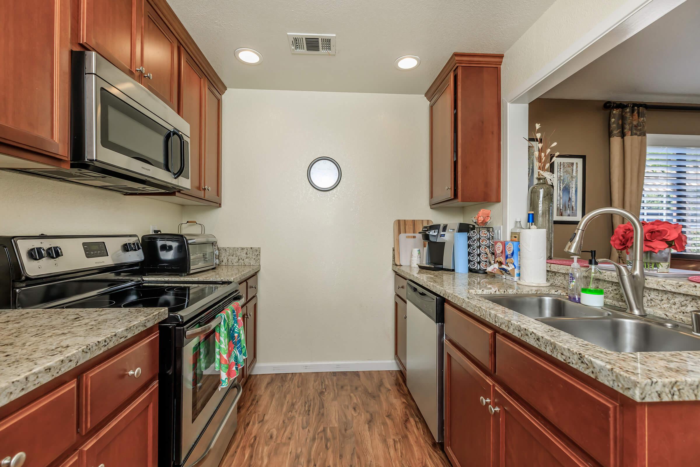 a large kitchen with stainless steel appliances and wooden cabinets