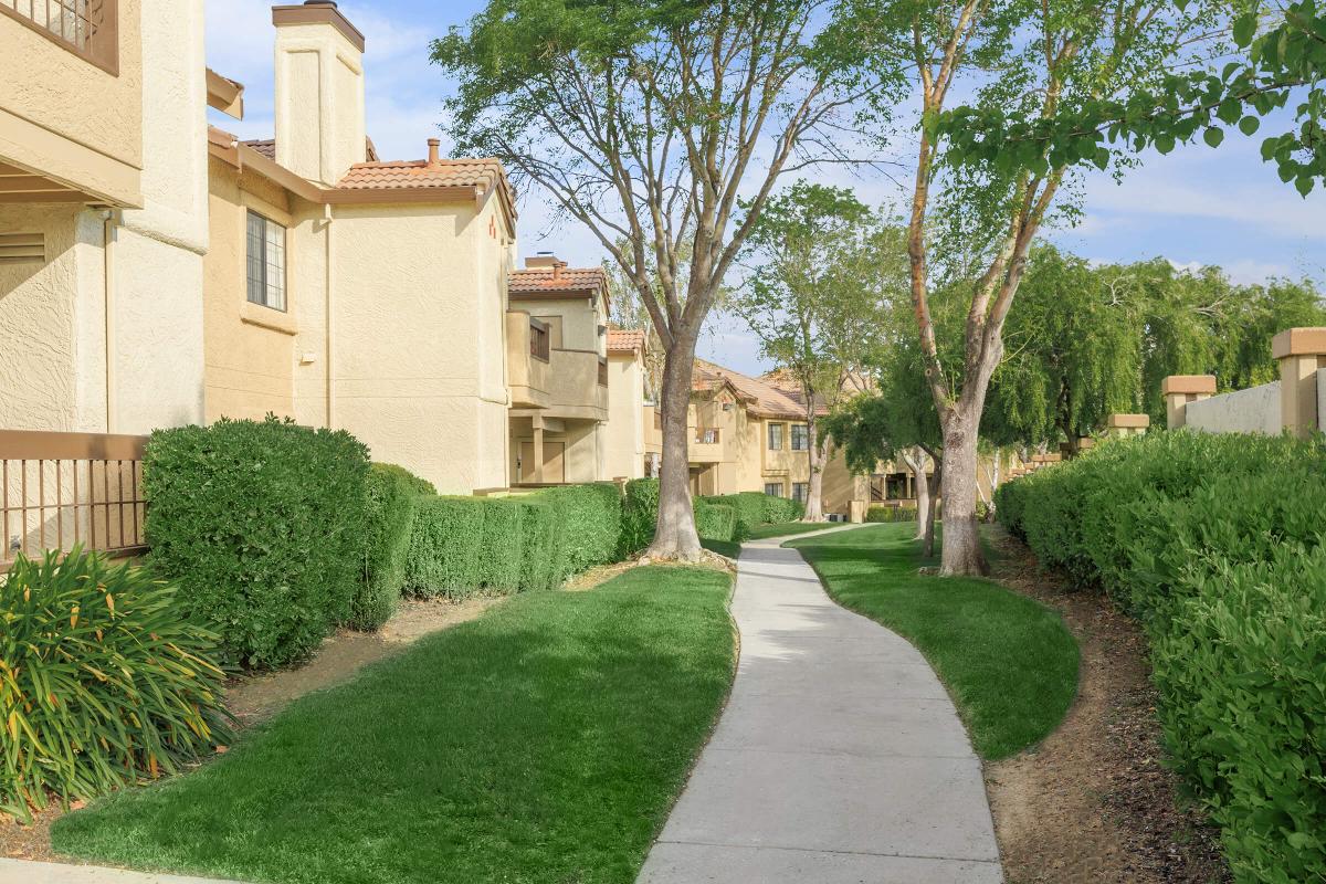 a path with grass in front of a brick building