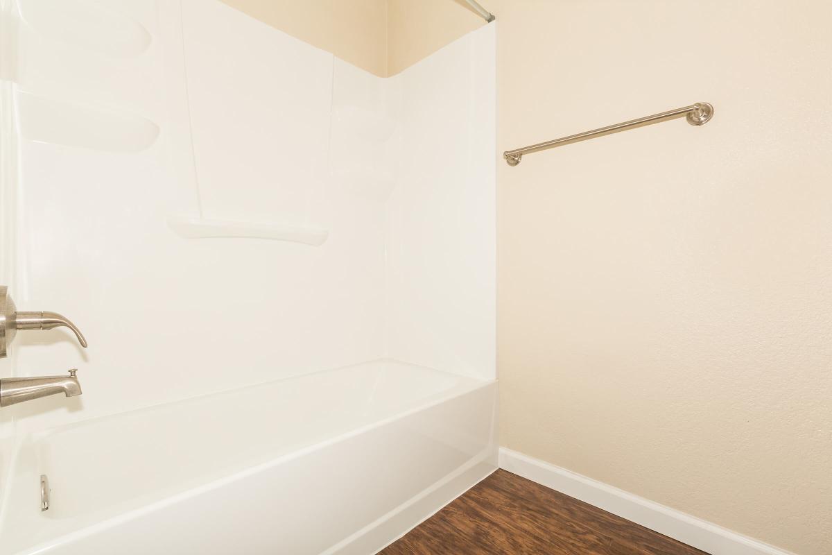 a white tub sitting next to a shower