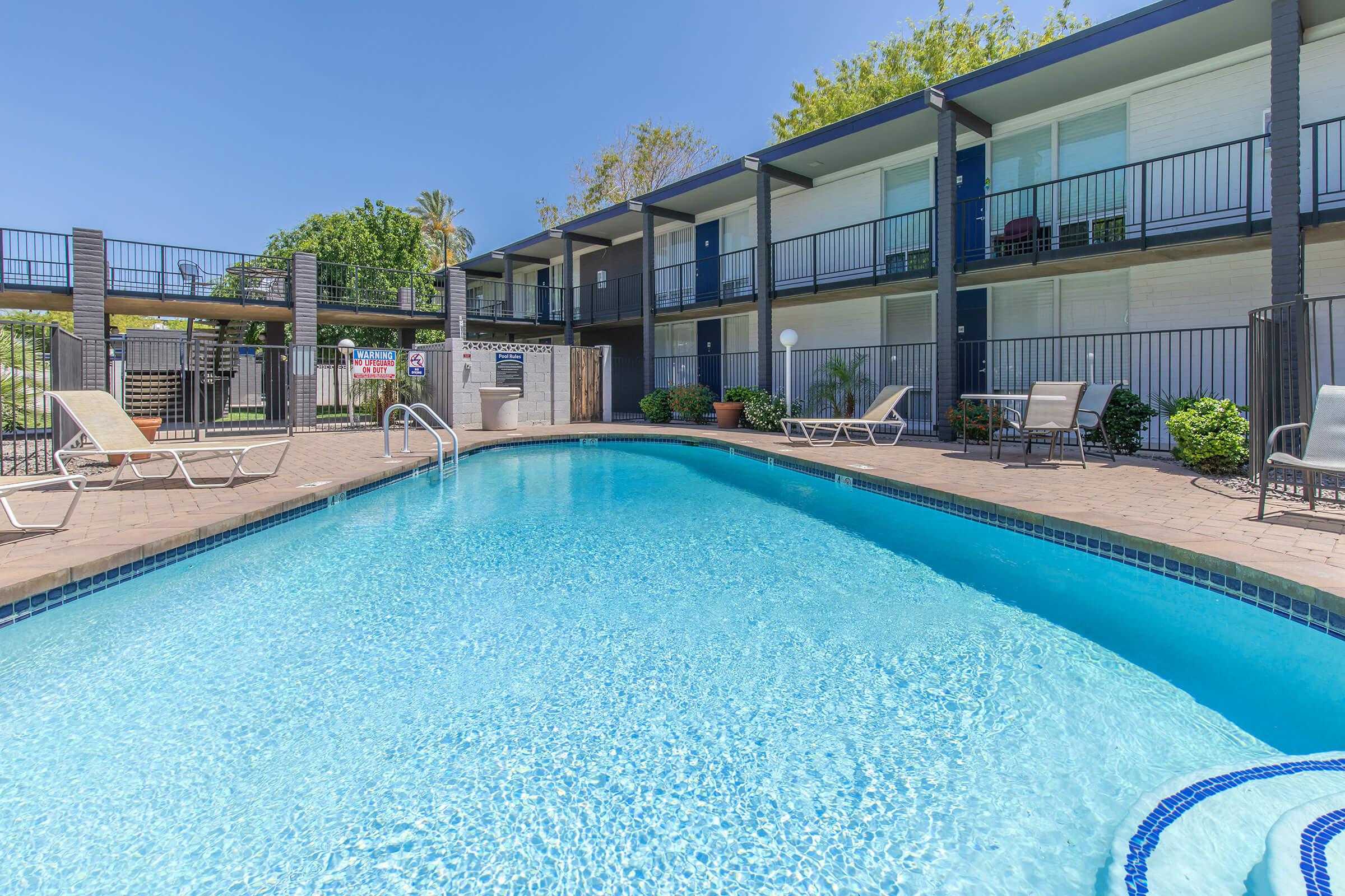 Blue outdoor swimming pool surrounded by apartment complex