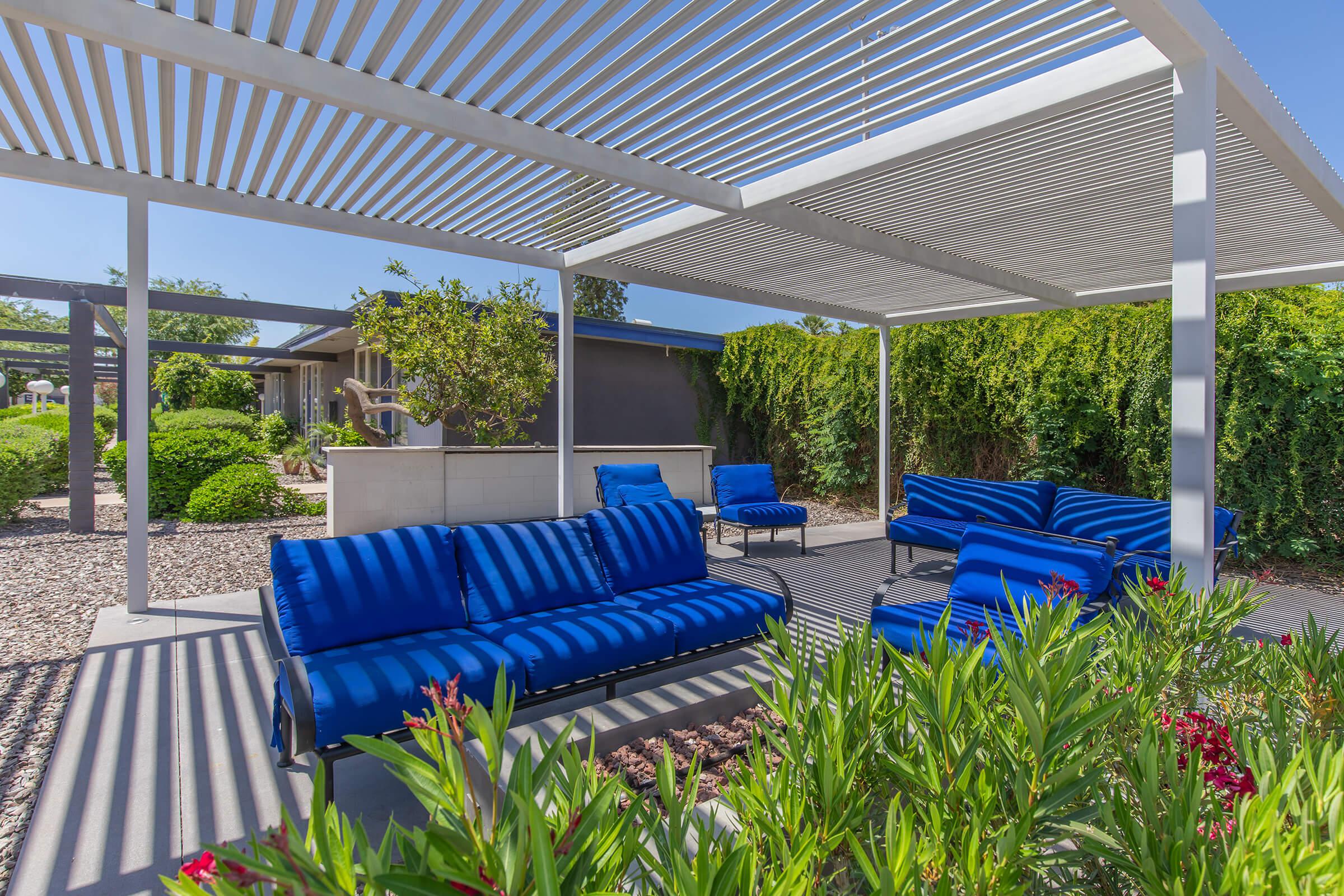 Phoenix, AZ outdoor shaded patio area with blue lounge couch seating around an electric fire pit