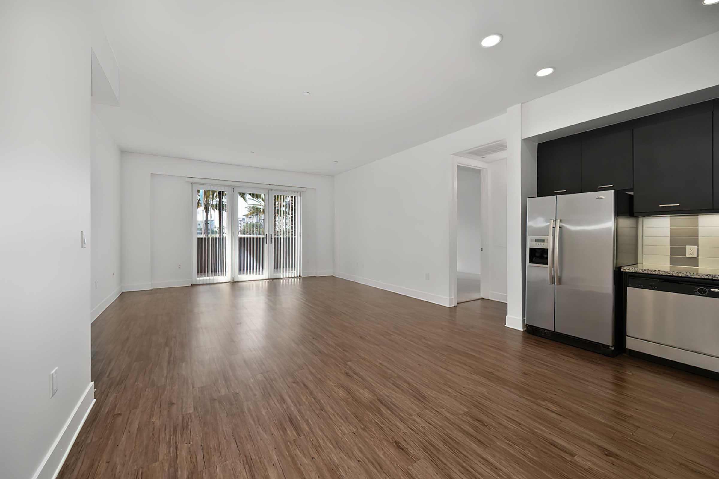 a room with a wood floor and kitchen