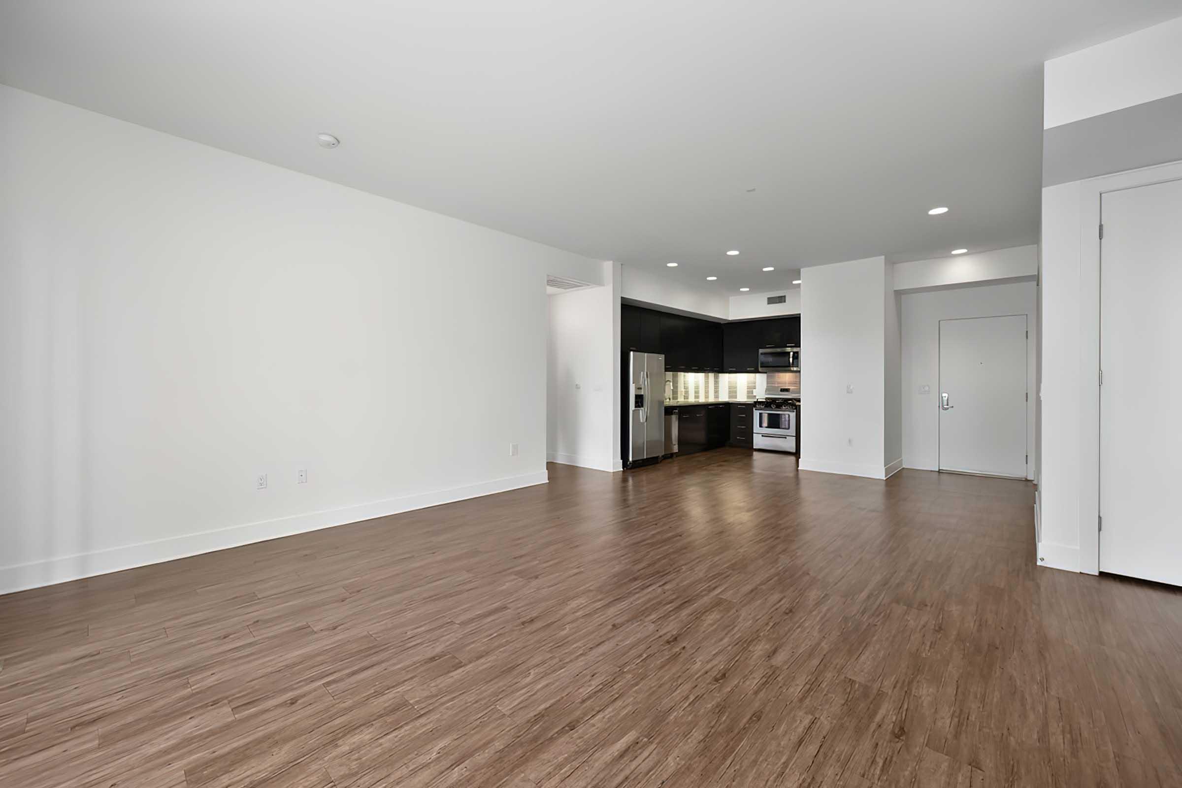 a large empty room with a kitchen