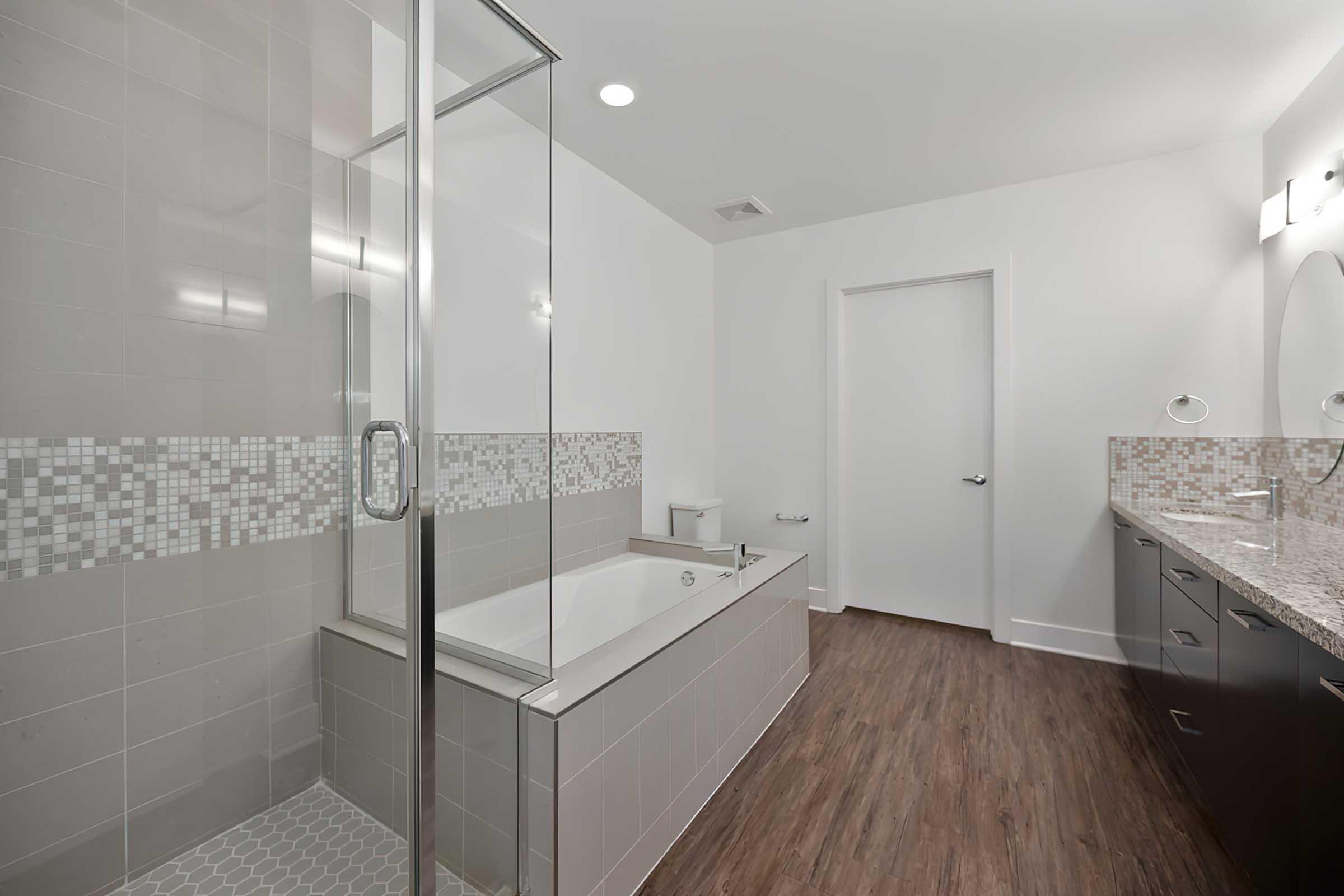 a tiled bathroom with tub and glass shower