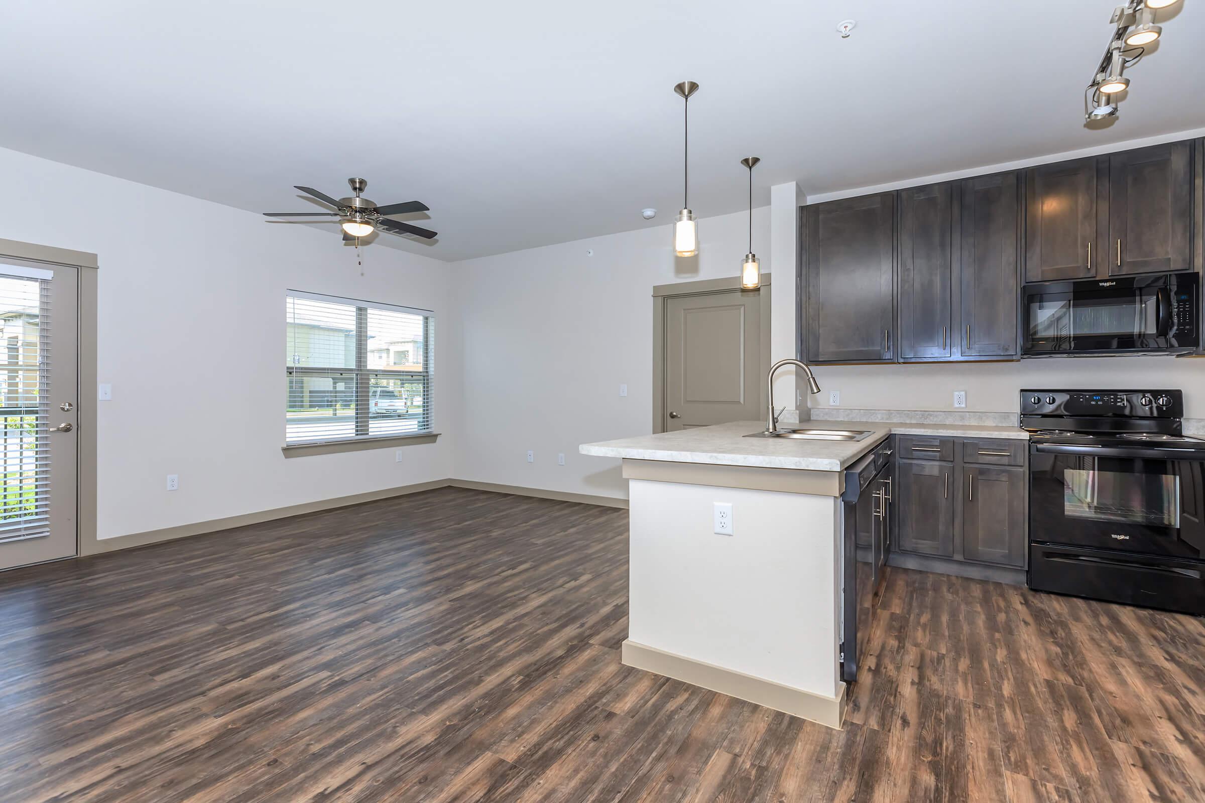 a large kitchen with stainless steel appliances and wooden cabinets