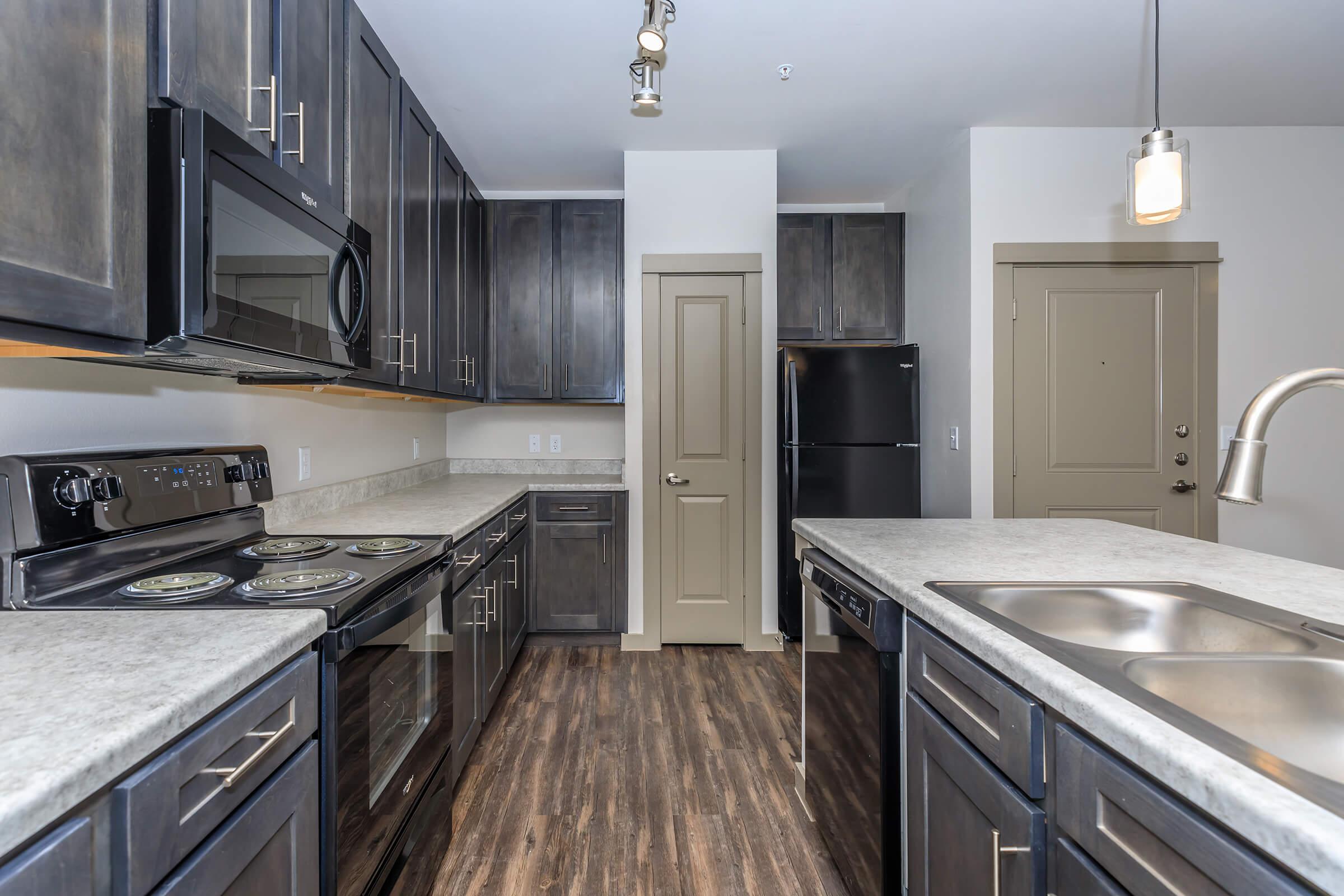 a large kitchen with stainless steel appliances and wooden cabinets