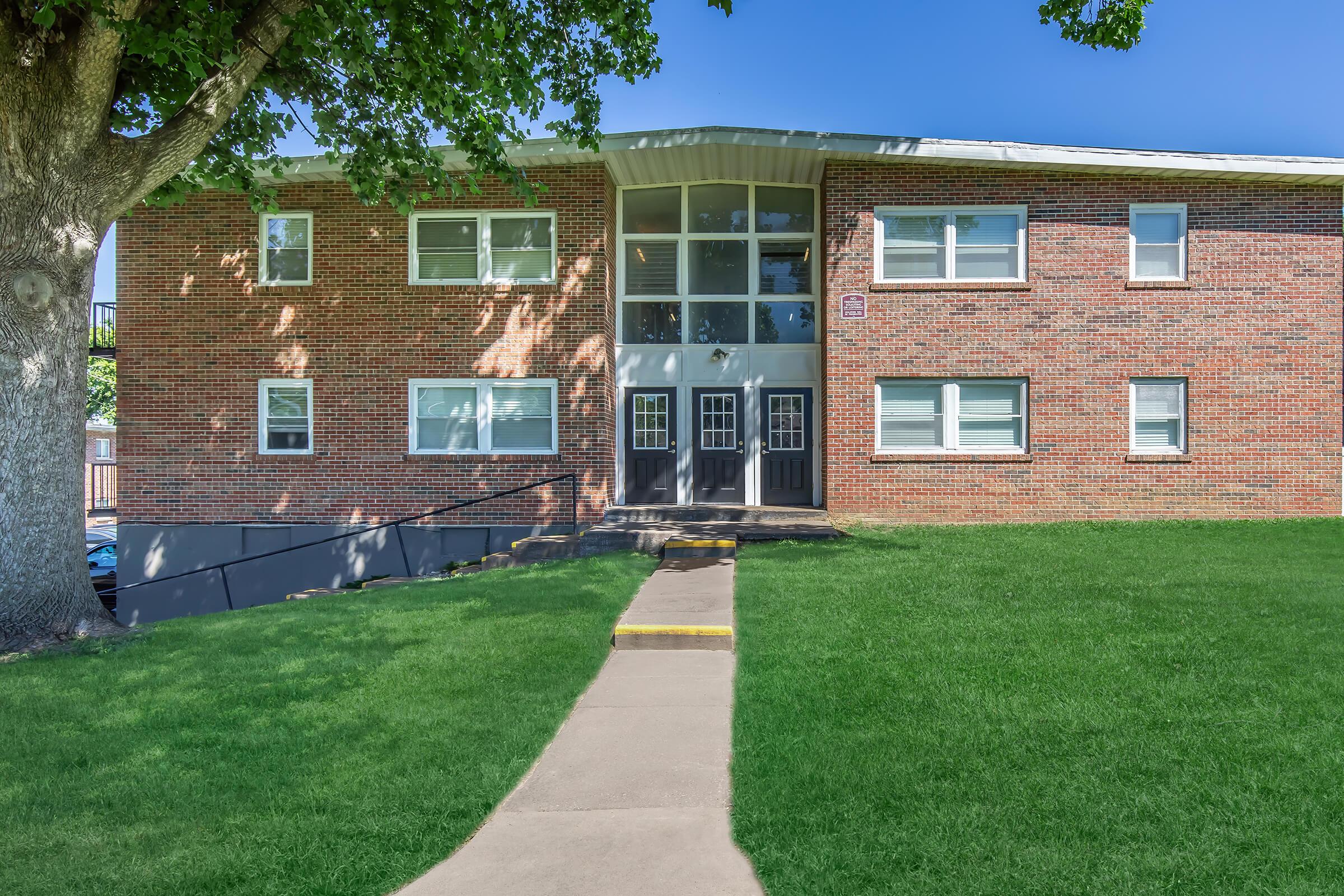 a large lawn in front of a brick building