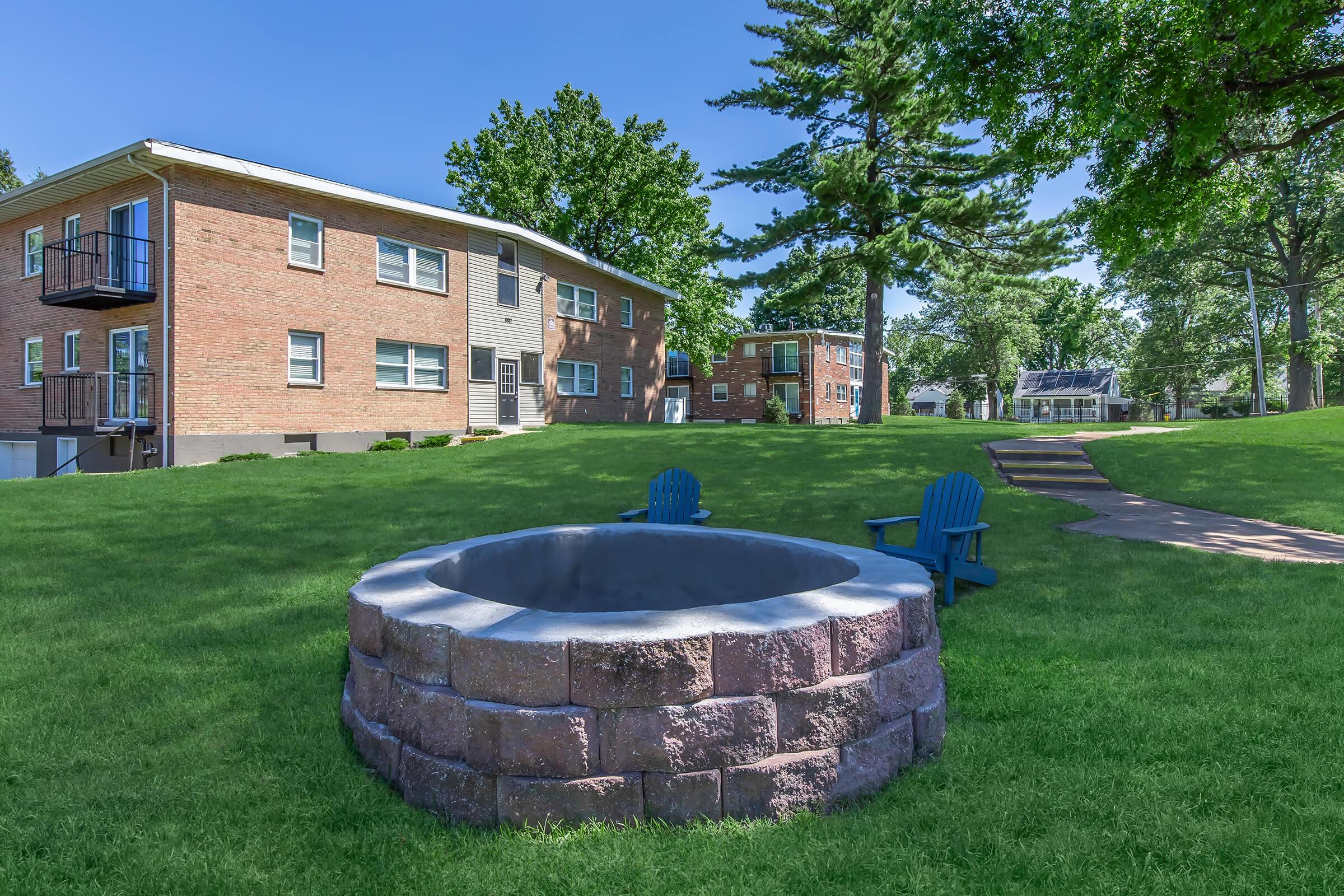 a house with a lawn in front of a brick building