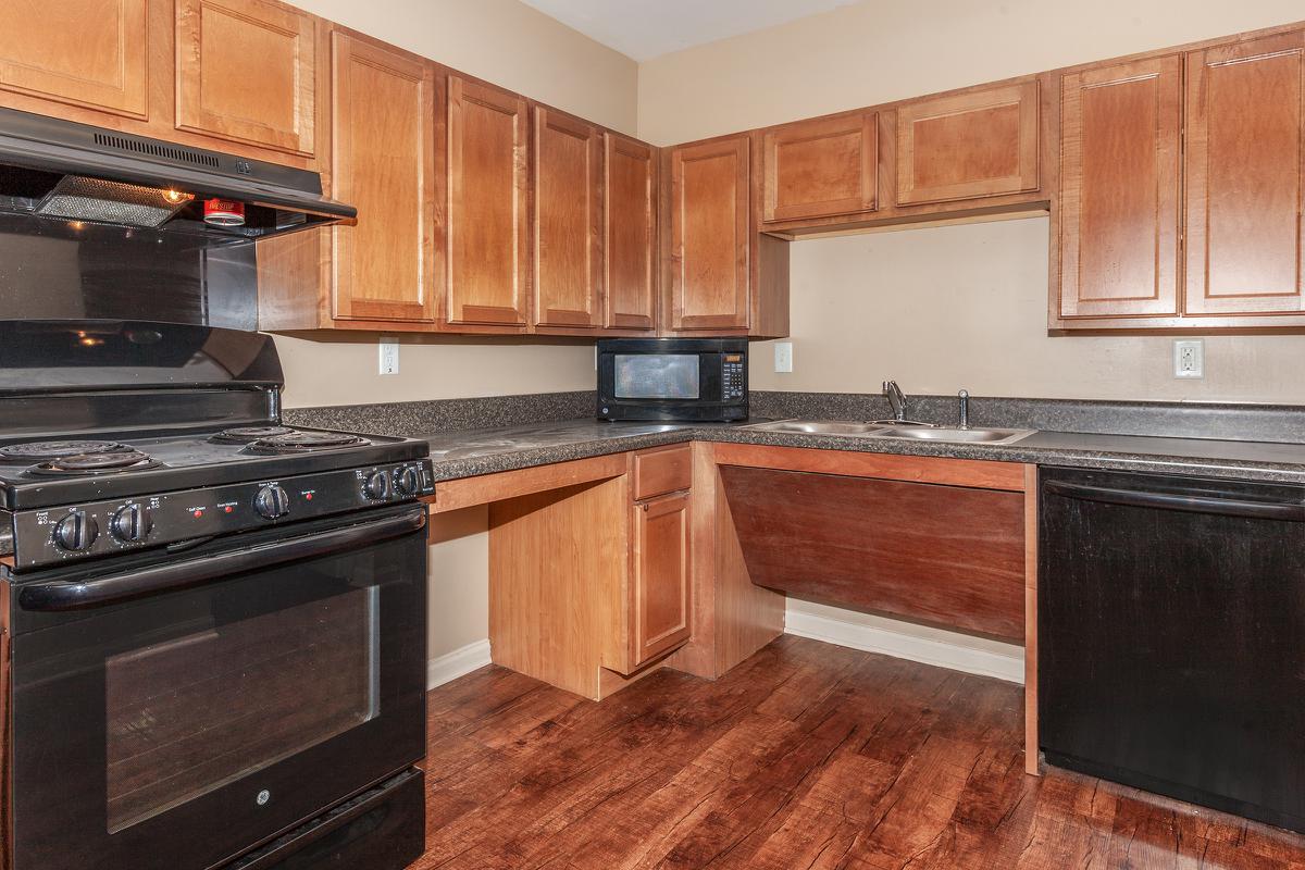 a kitchen with wooden cabinets and a black stove top oven