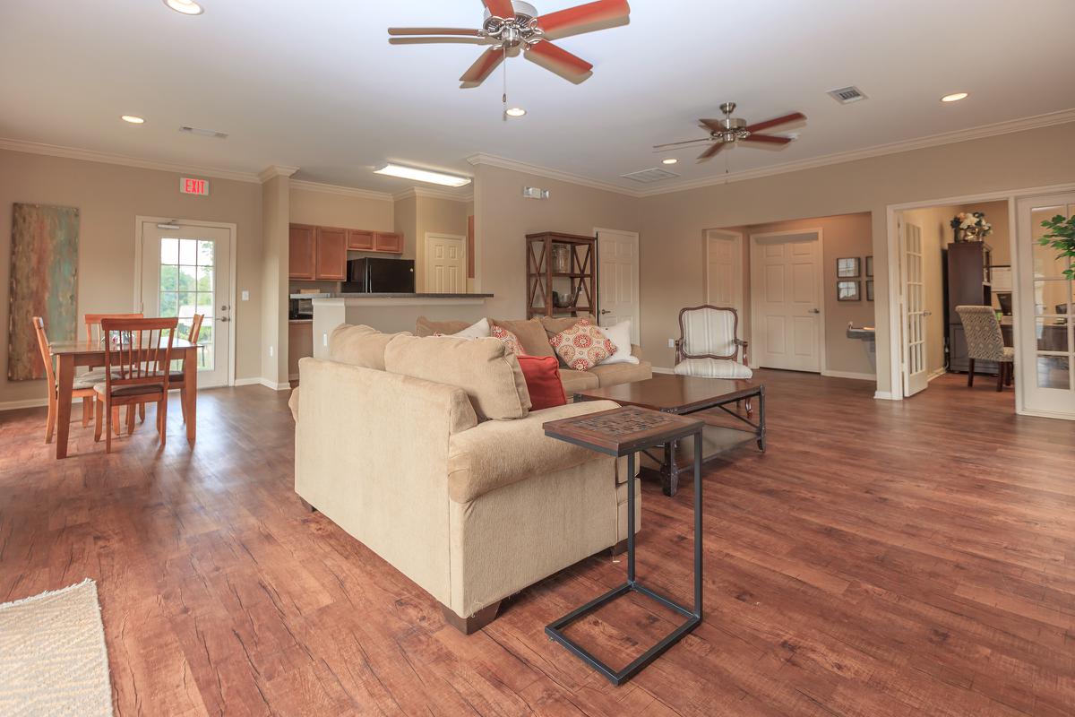 a living room filled with furniture on top of a hard wood floor