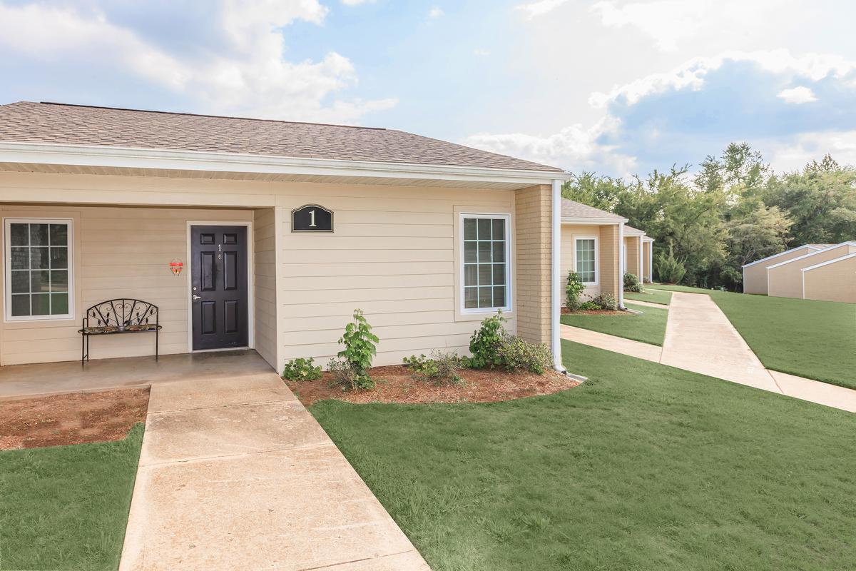 a large brick building with grass in front of a house