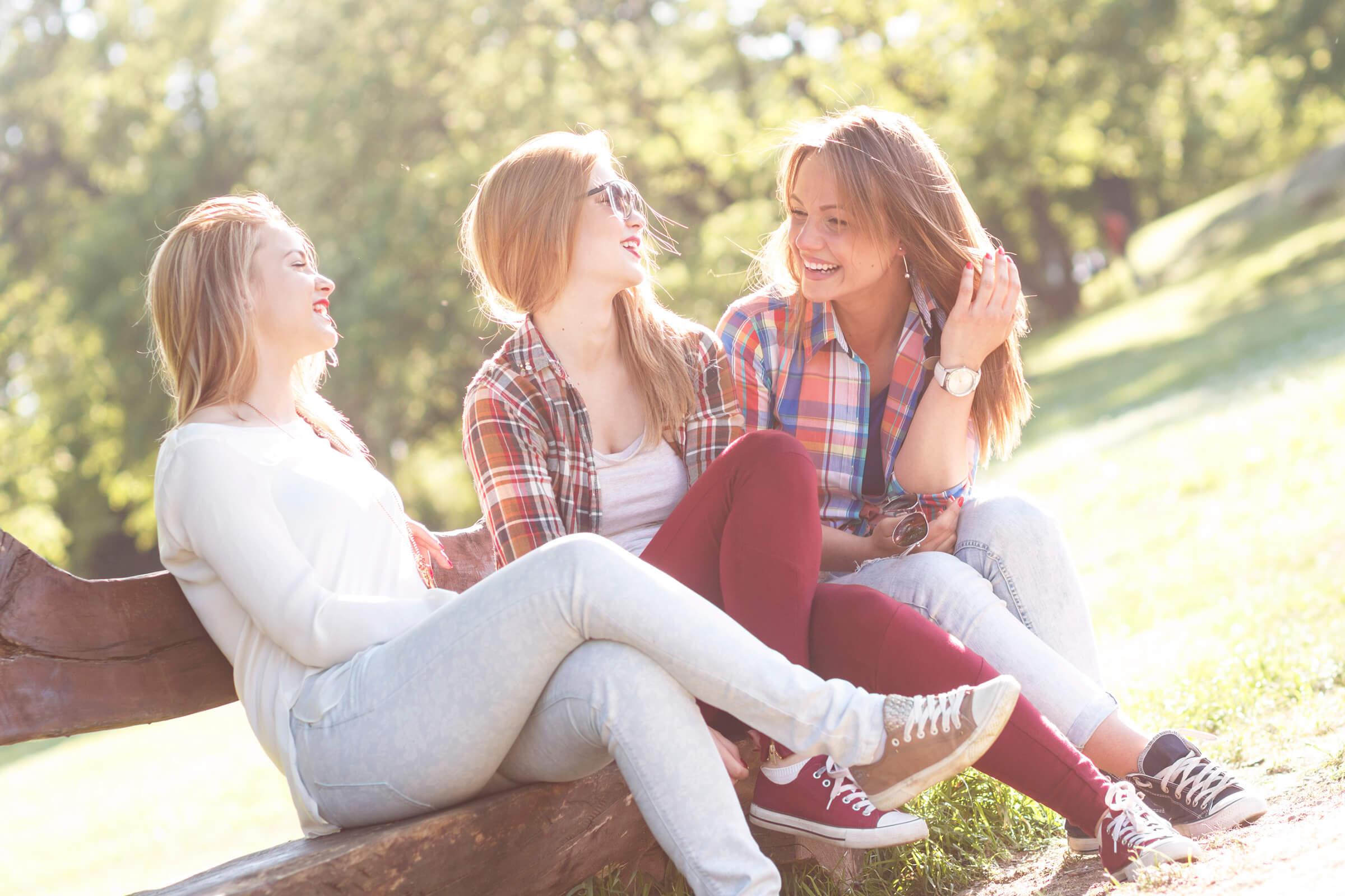 Three friends sitting on a park bench and chatting iStock_63573117_LARGE.jpg