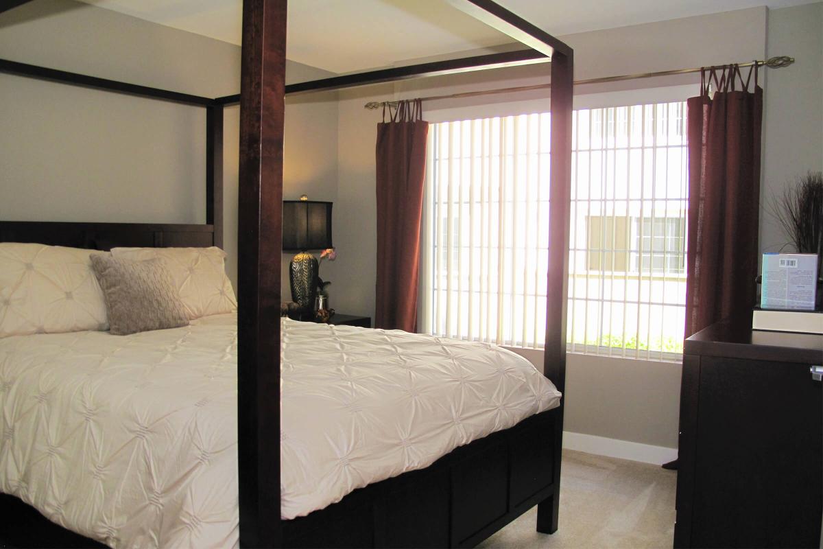 a bedroom with a bed and desk in a room