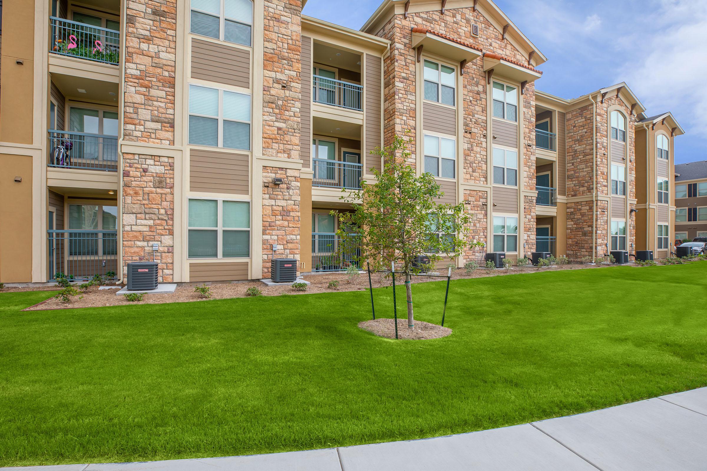 a large lawn in front of a brick building