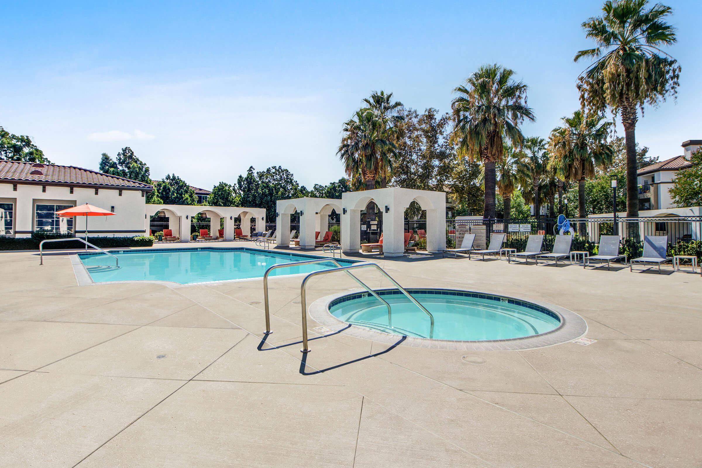 a pool next to a palm tree on a beach