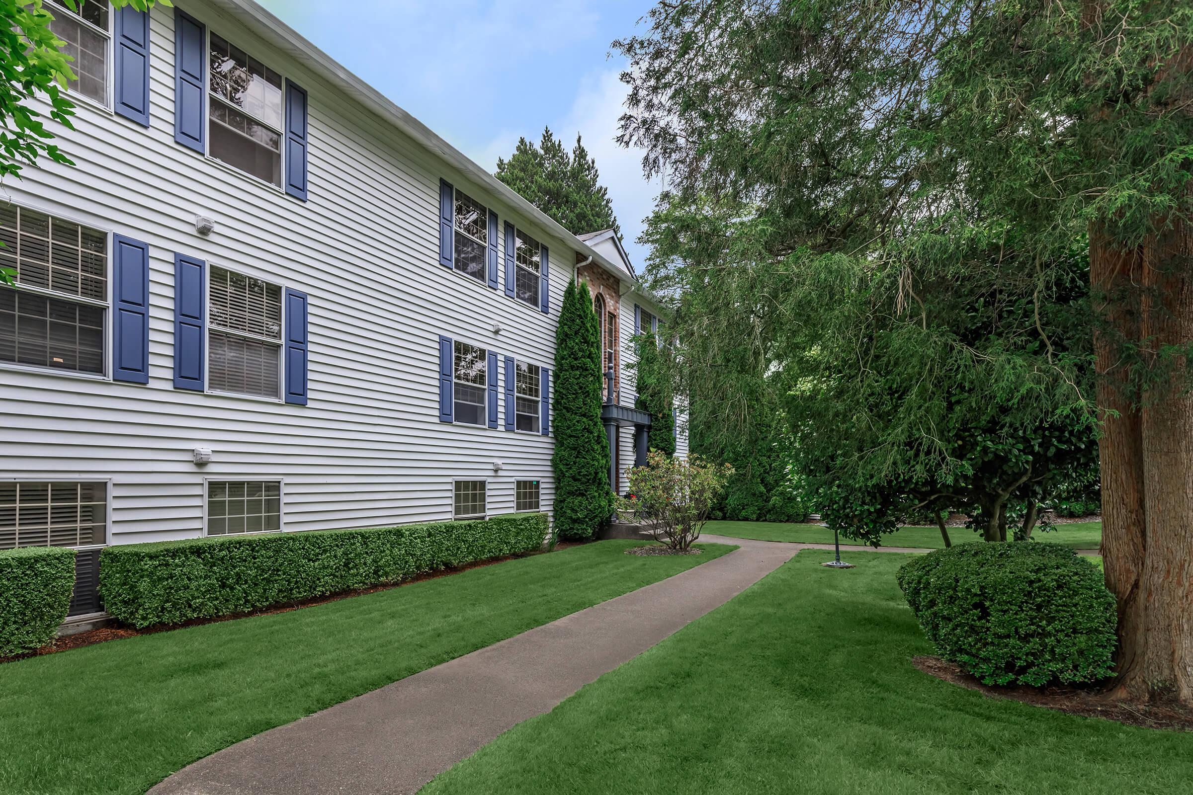 a large brick building with grass in front of a house