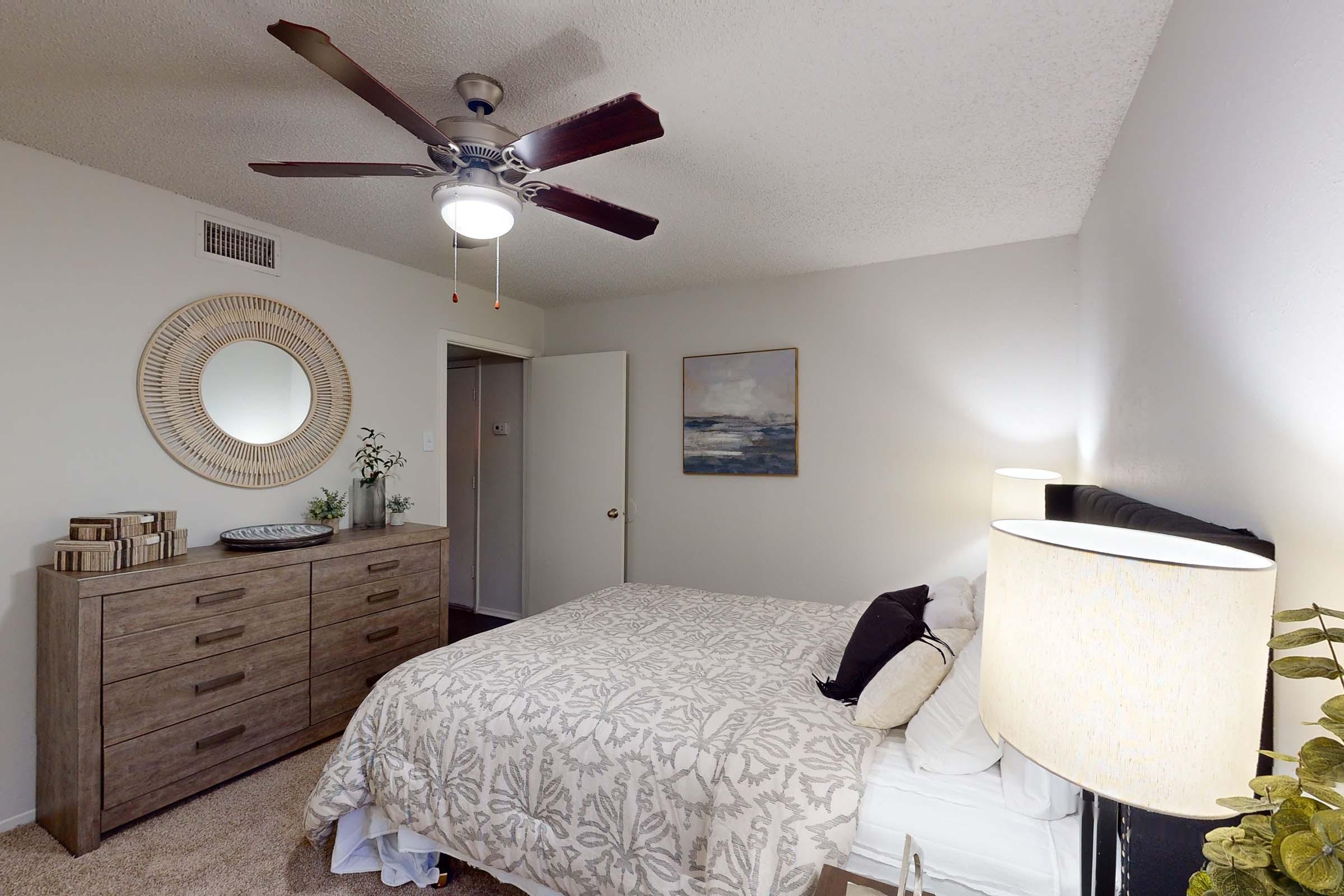 a bedroom with a bed and desk in a room