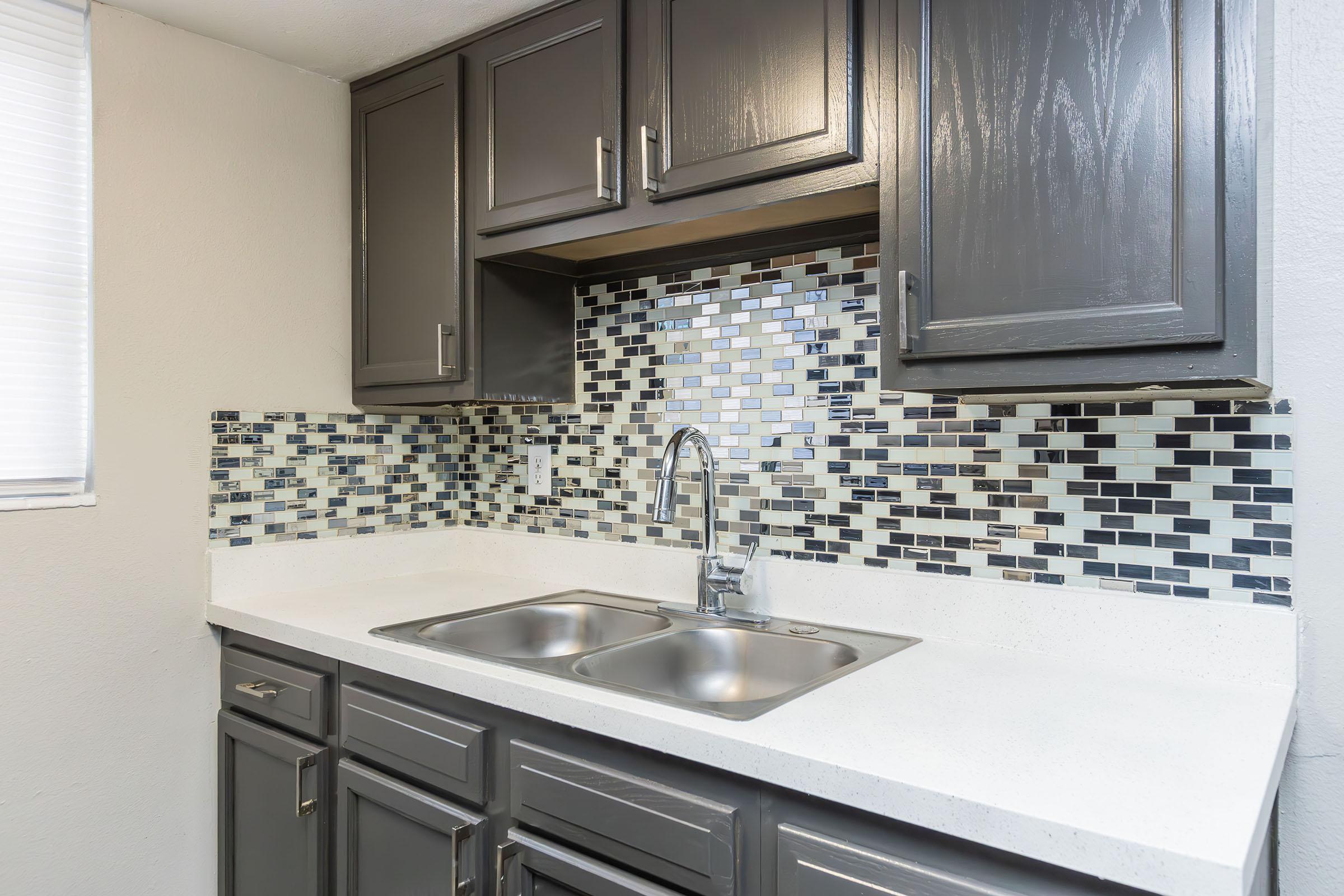 a kitchen with a sink and a mirror