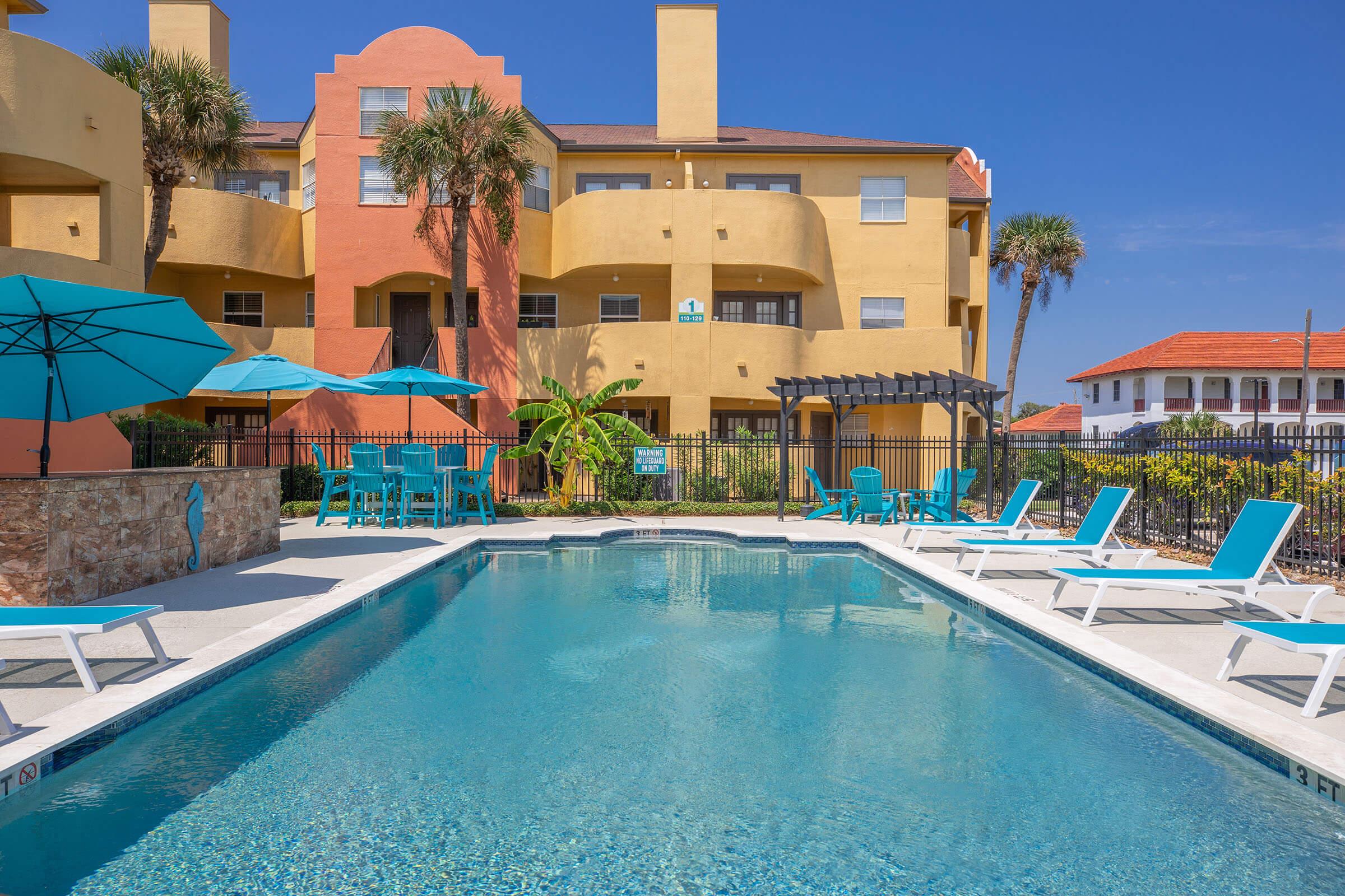 a blue umbrella sitting next to a pool of water